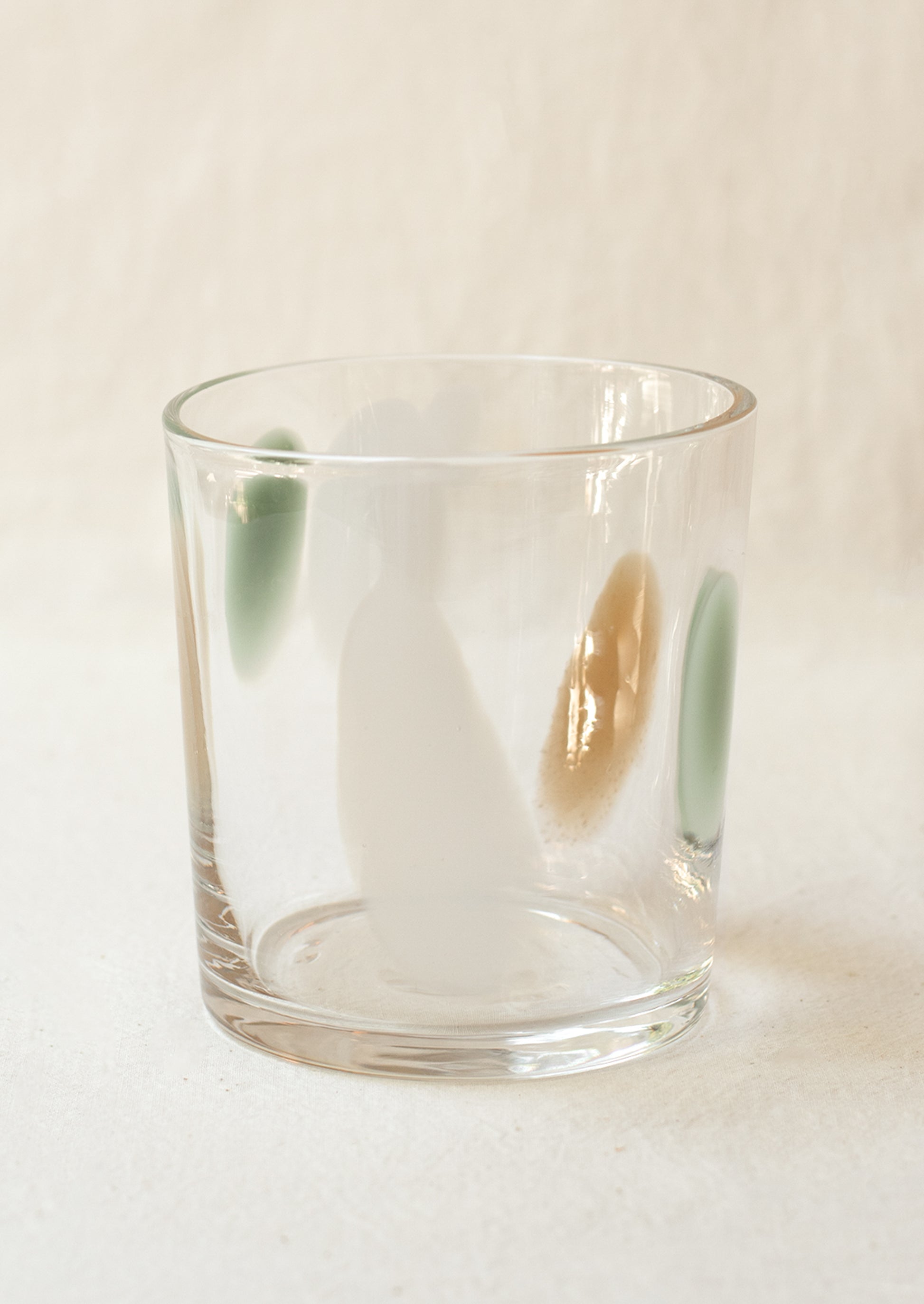 A clear glass tumbler with mint, brown and white speckle pattern.