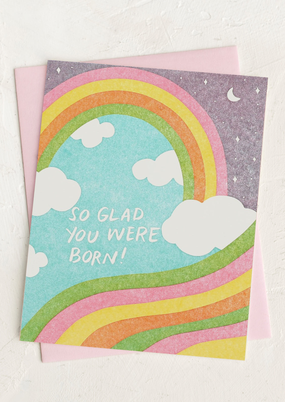 A rainbow and cloud print card reading "So glad you were born!".