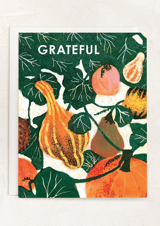Greeting card with pumpkins, gourds, and the word 'Grateful' on a green background.