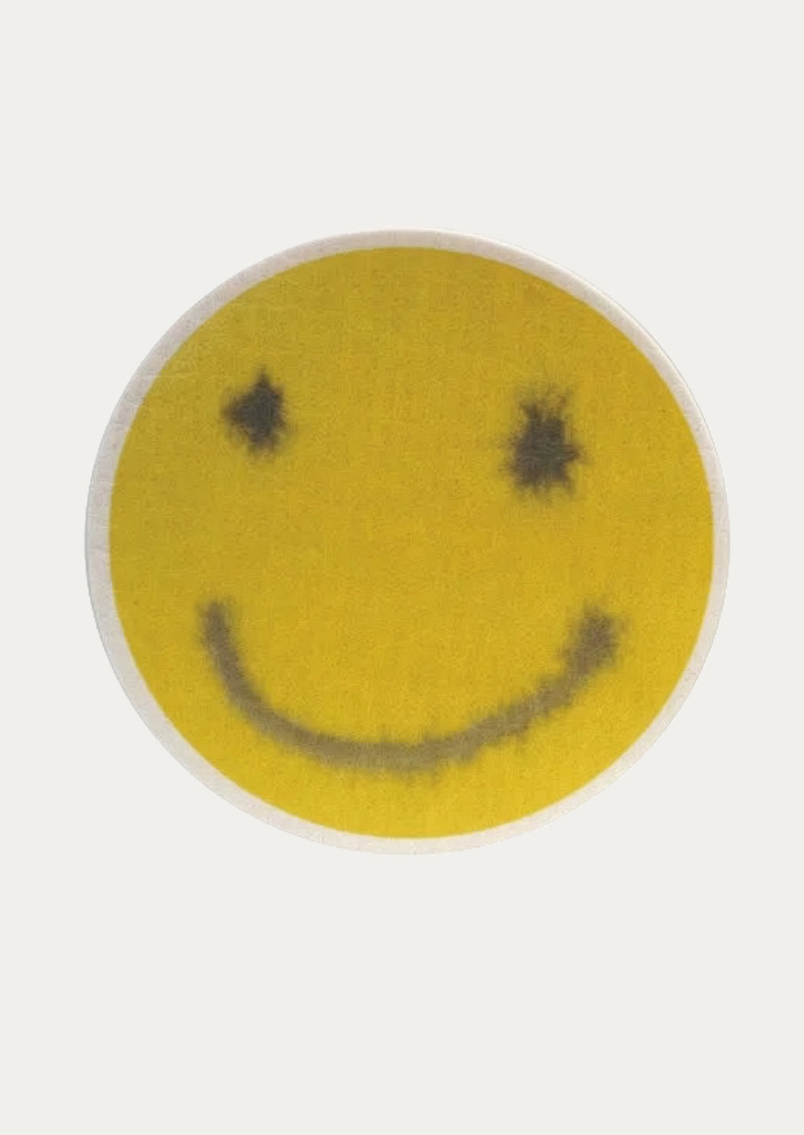 Smiley face sponge with black dots on a white background