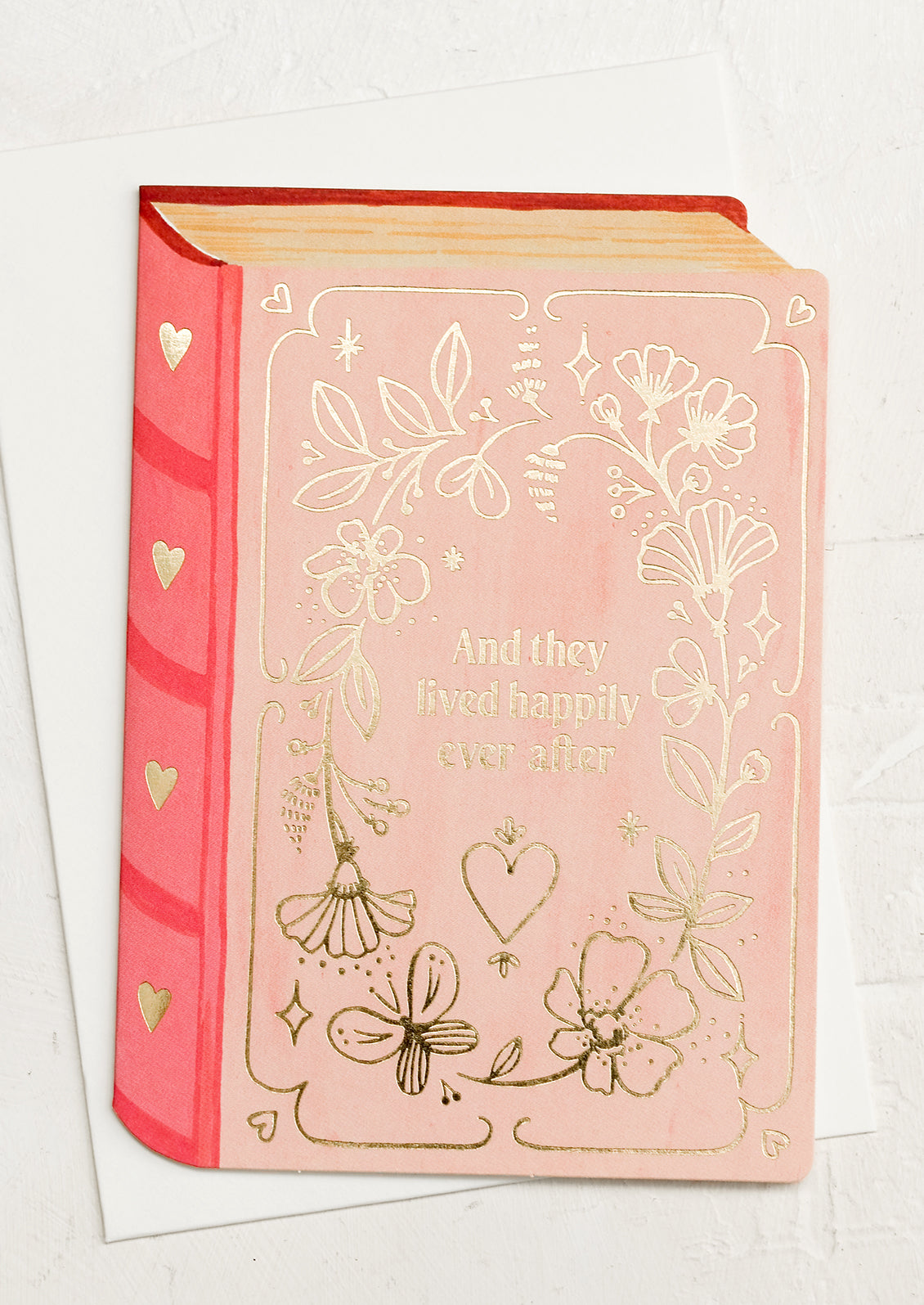 A book shaped diecut card reading "And they lived happily ever after".