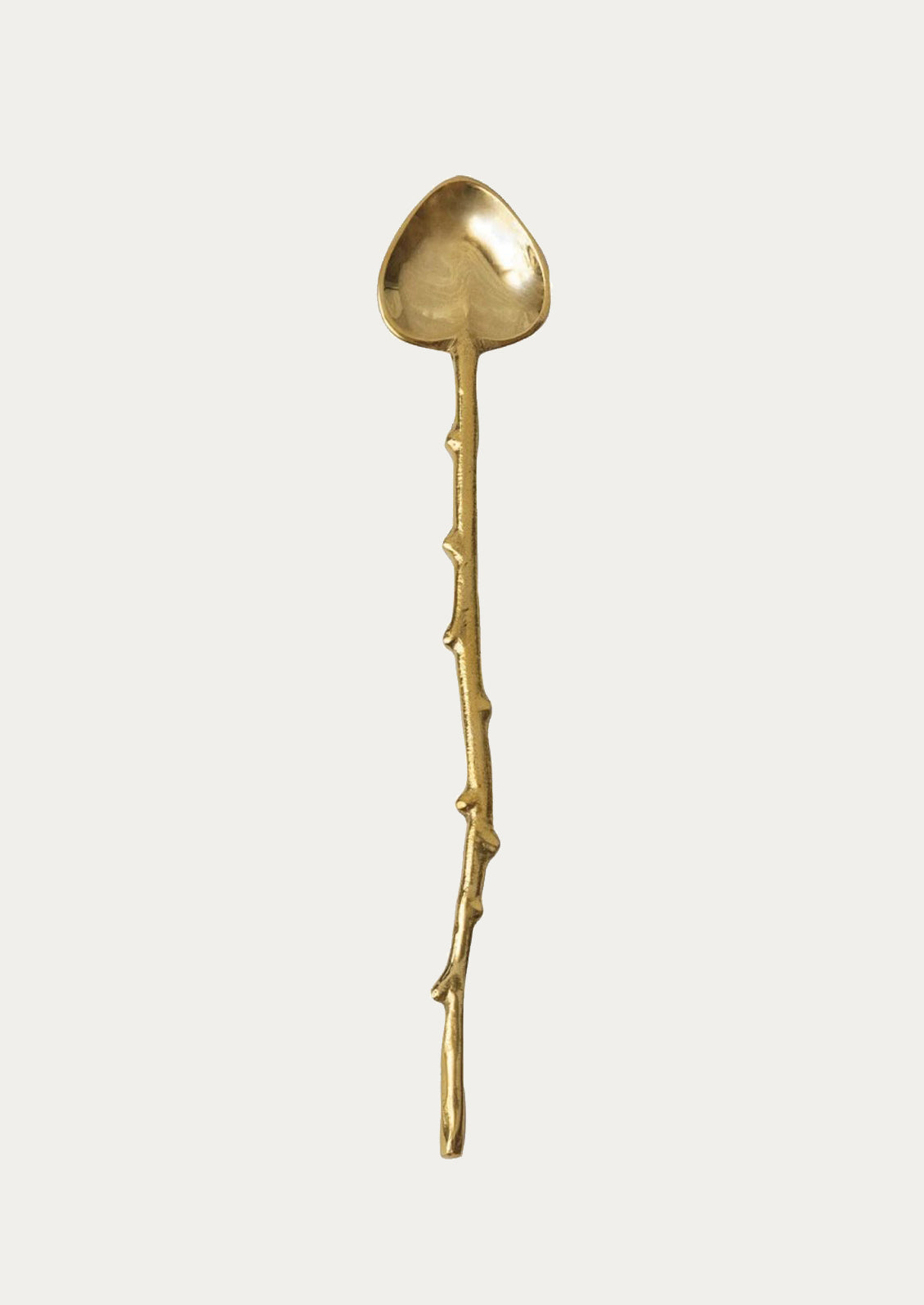 A brass spoon in heart shape with twig-cast handle.