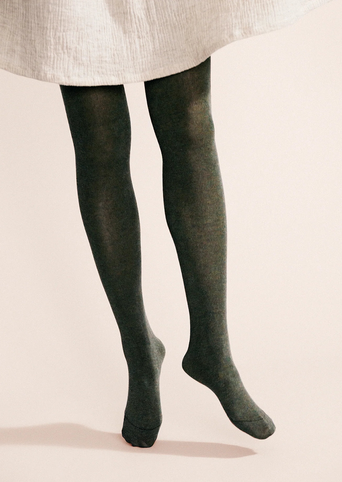 A person wearing knit tights in green.