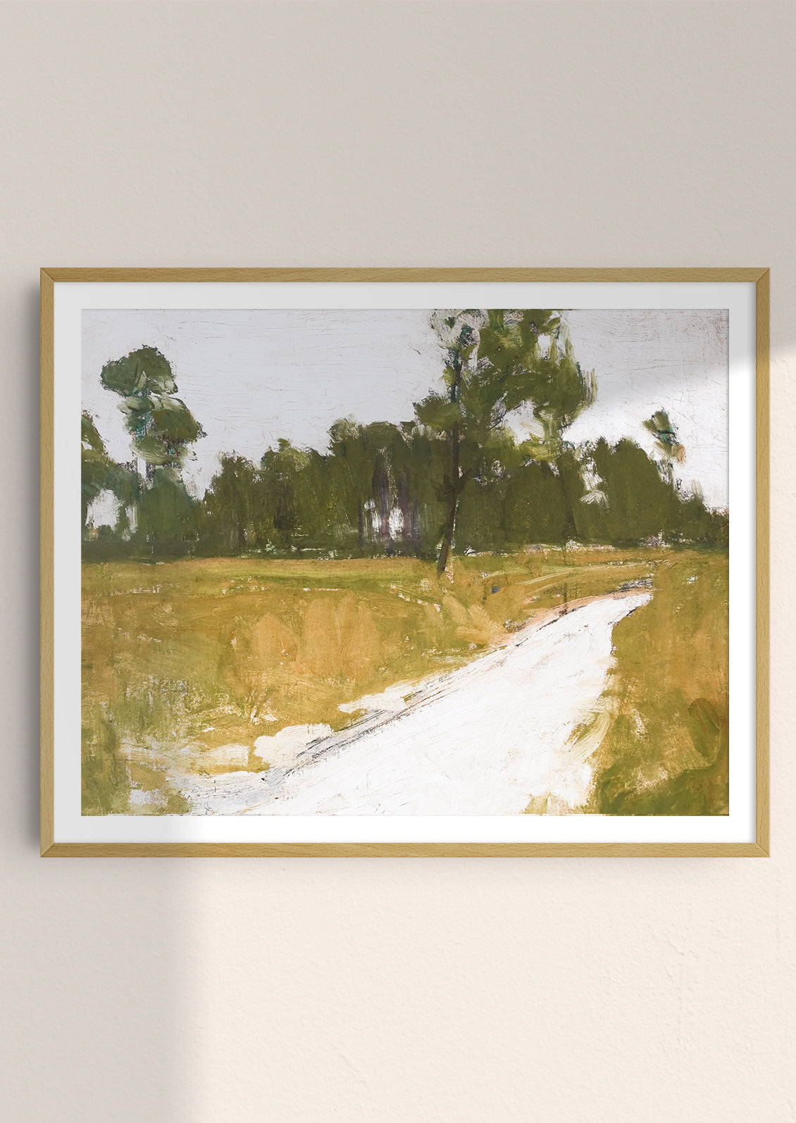 An art print of painting of road along the woods in frame.