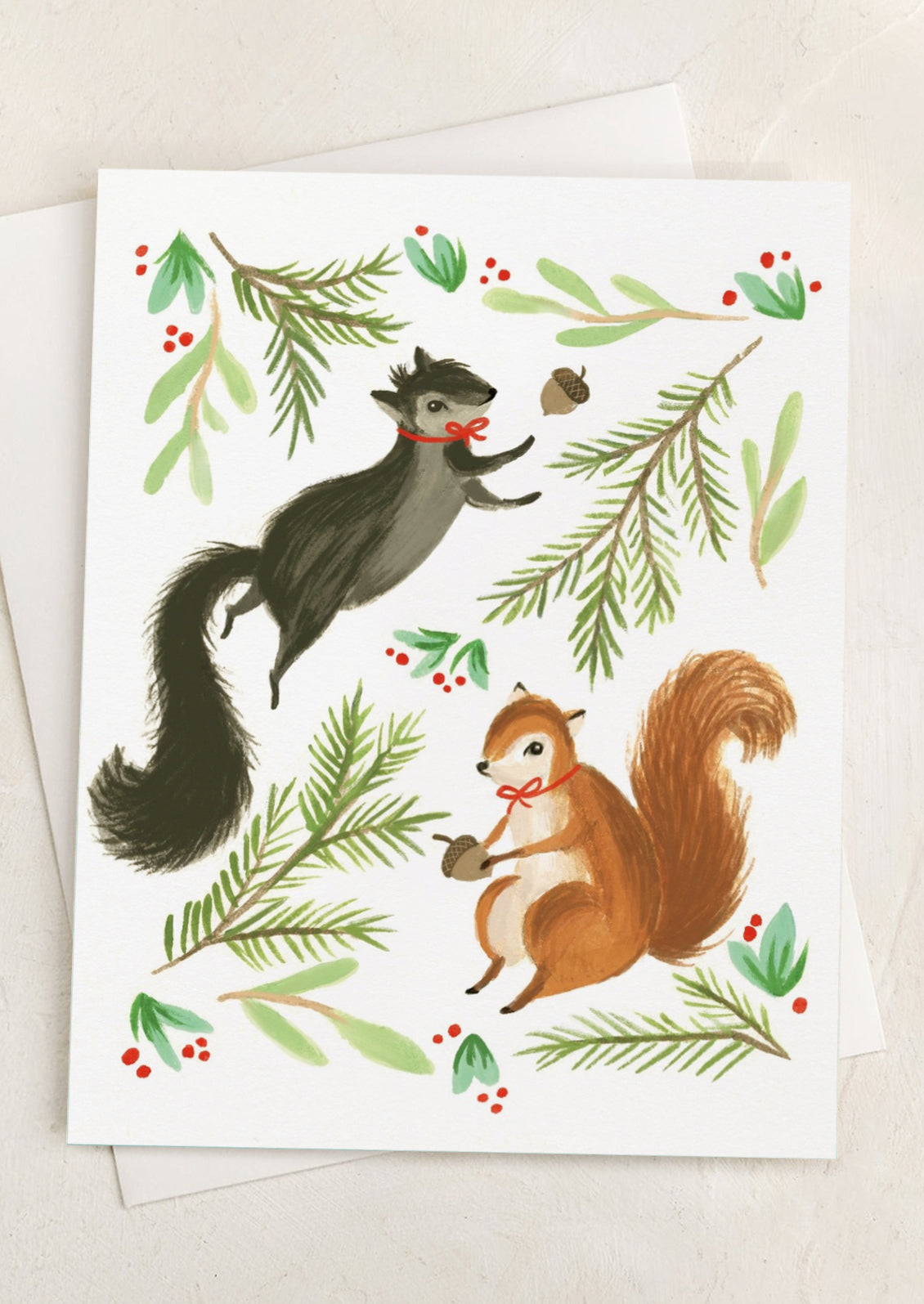 A greeting card with illustration of squirrels wearing red ribbons.