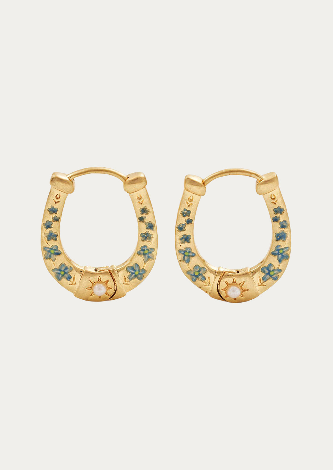 A pair of hold horseshoe shaped gold earrings with blue flowers.