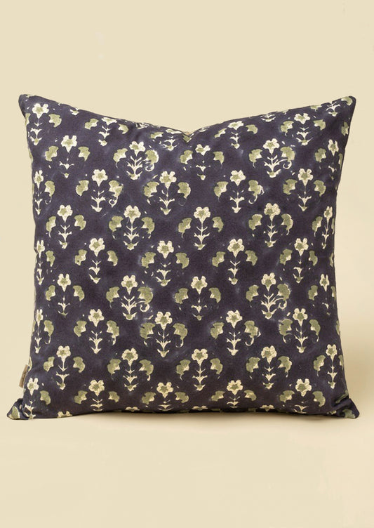 A block printed throw pillow with dark blue background and sage green floral print.