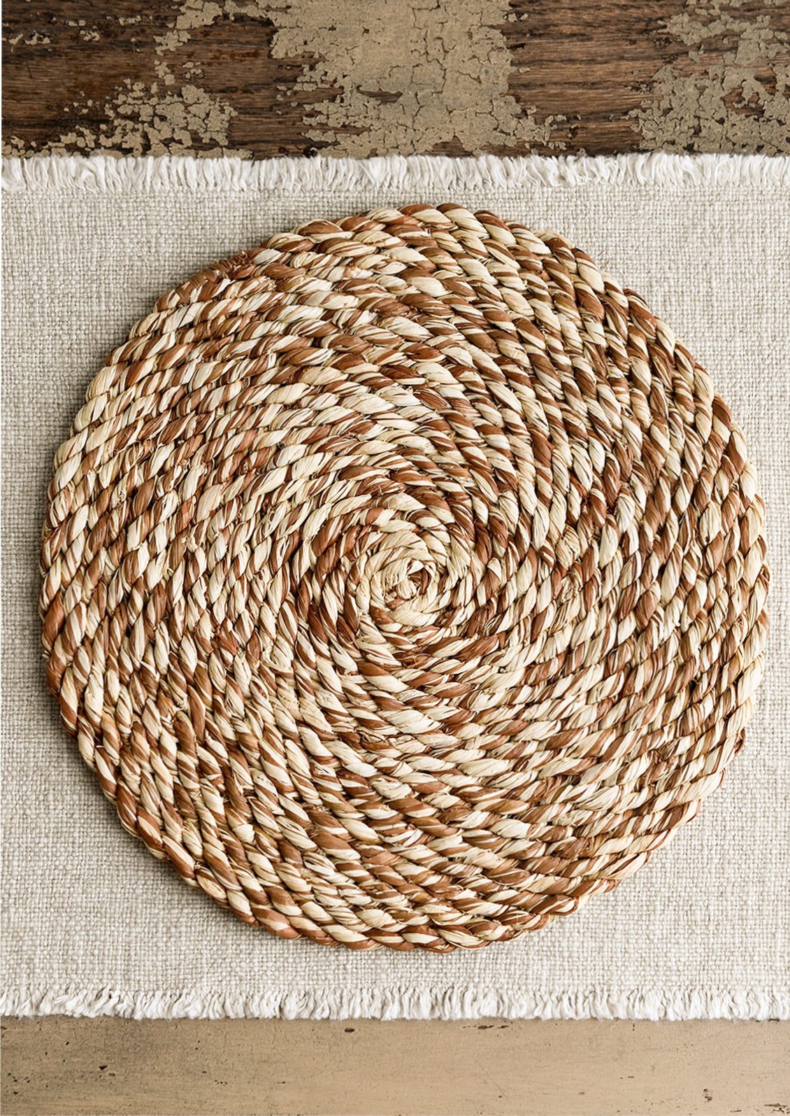A placemat on a linen table runner.