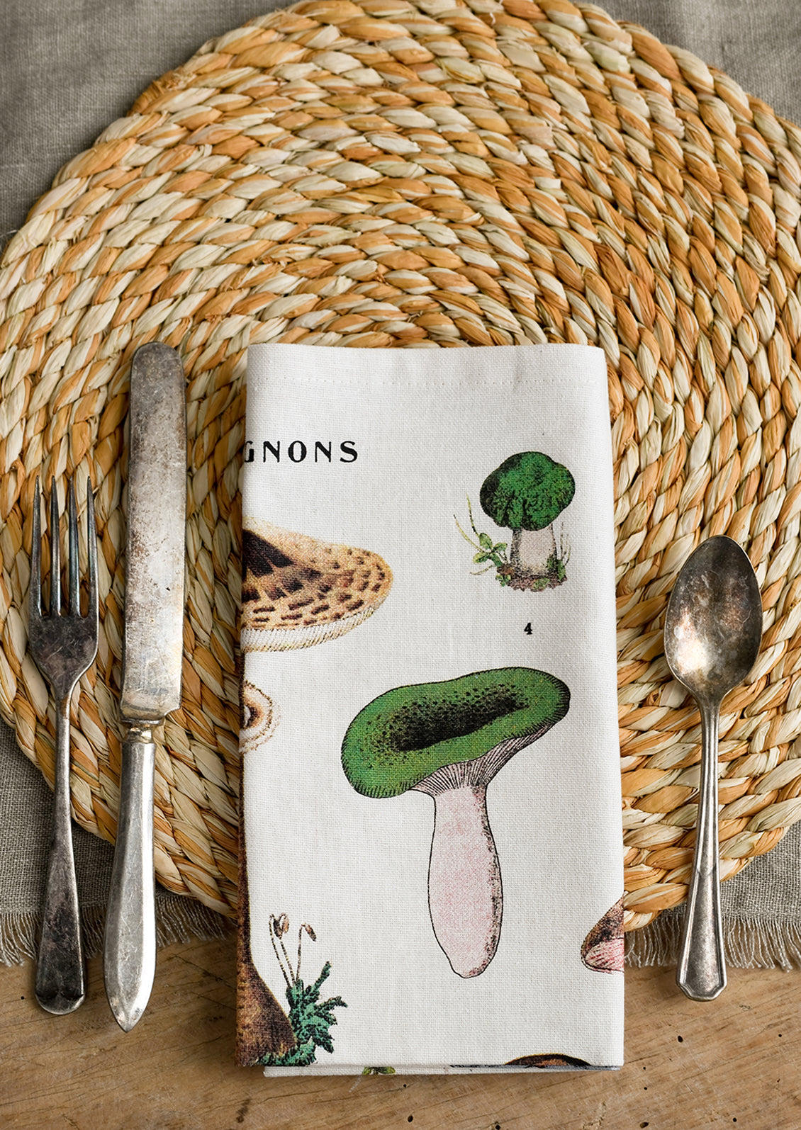A place setting with mushroom print napkin, folded.