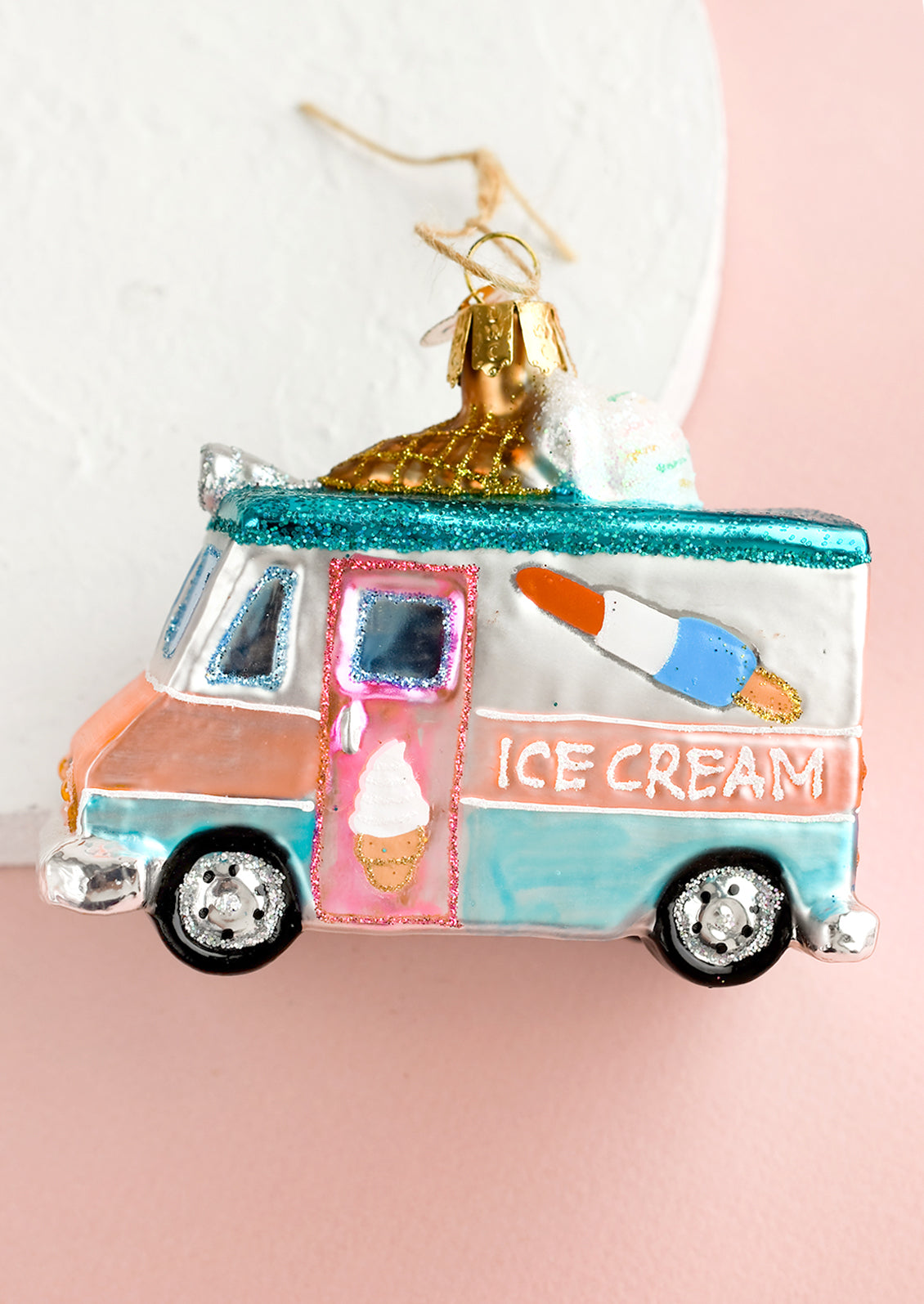 A holiday glass ornament of an ice cream truck.