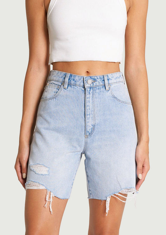 A pair of light blue denim shorts with mid-length and distressed detailing at hemline.