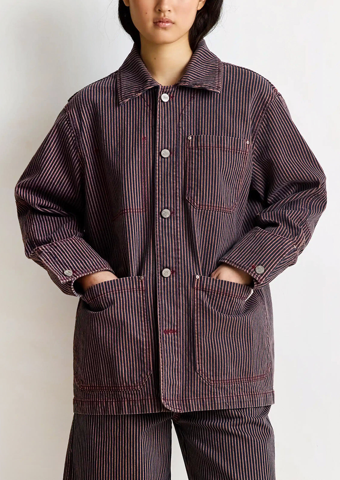 Person wearing a brown striped jacket and pants on a white background