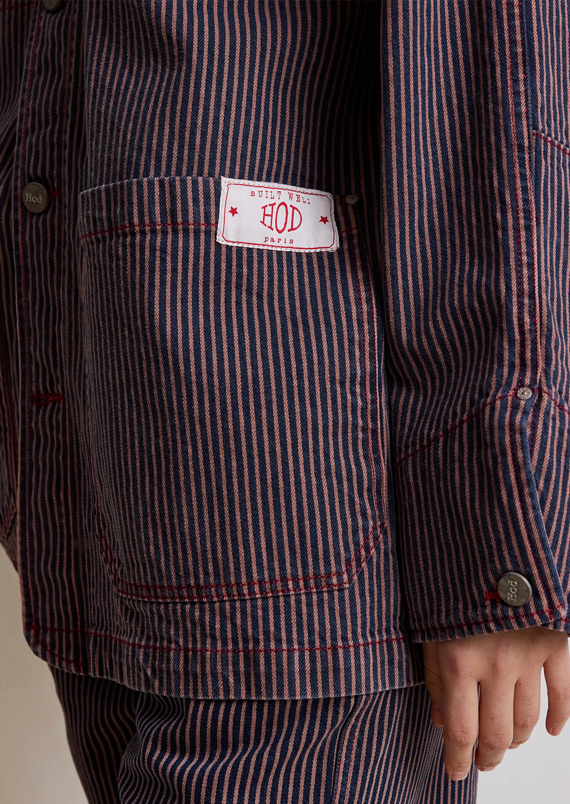 Person wearing a brown striped jacket and pants on a white background