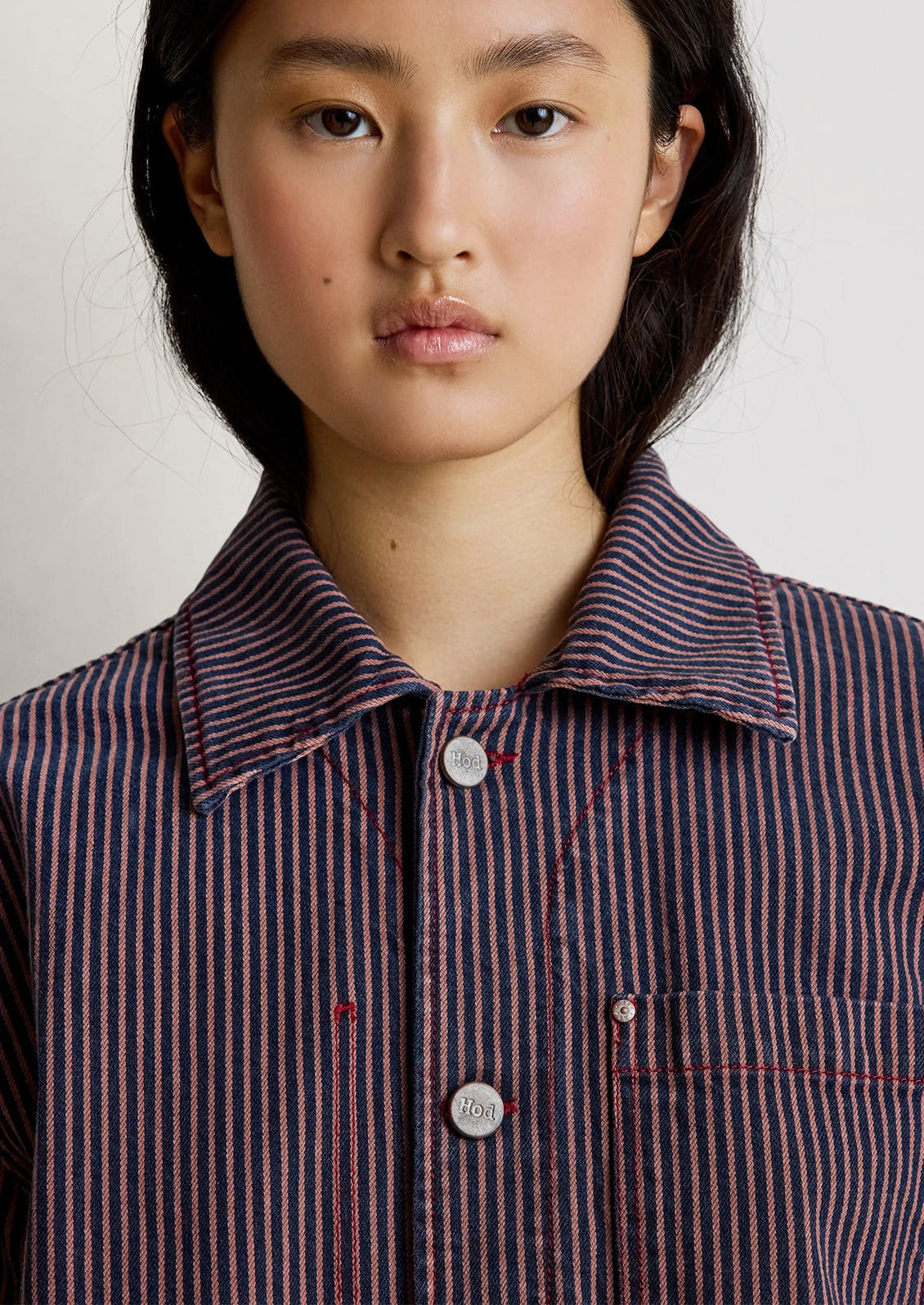 Person wearing a brown striped jacket and pants on a white background