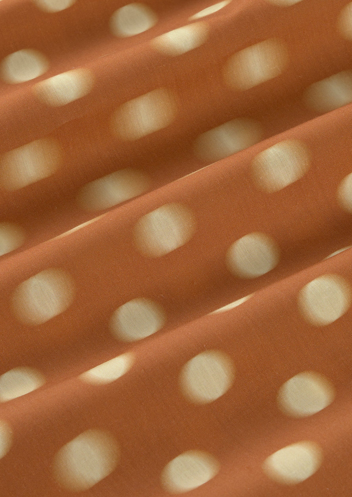 Close-up of orange fabric with white polka dots