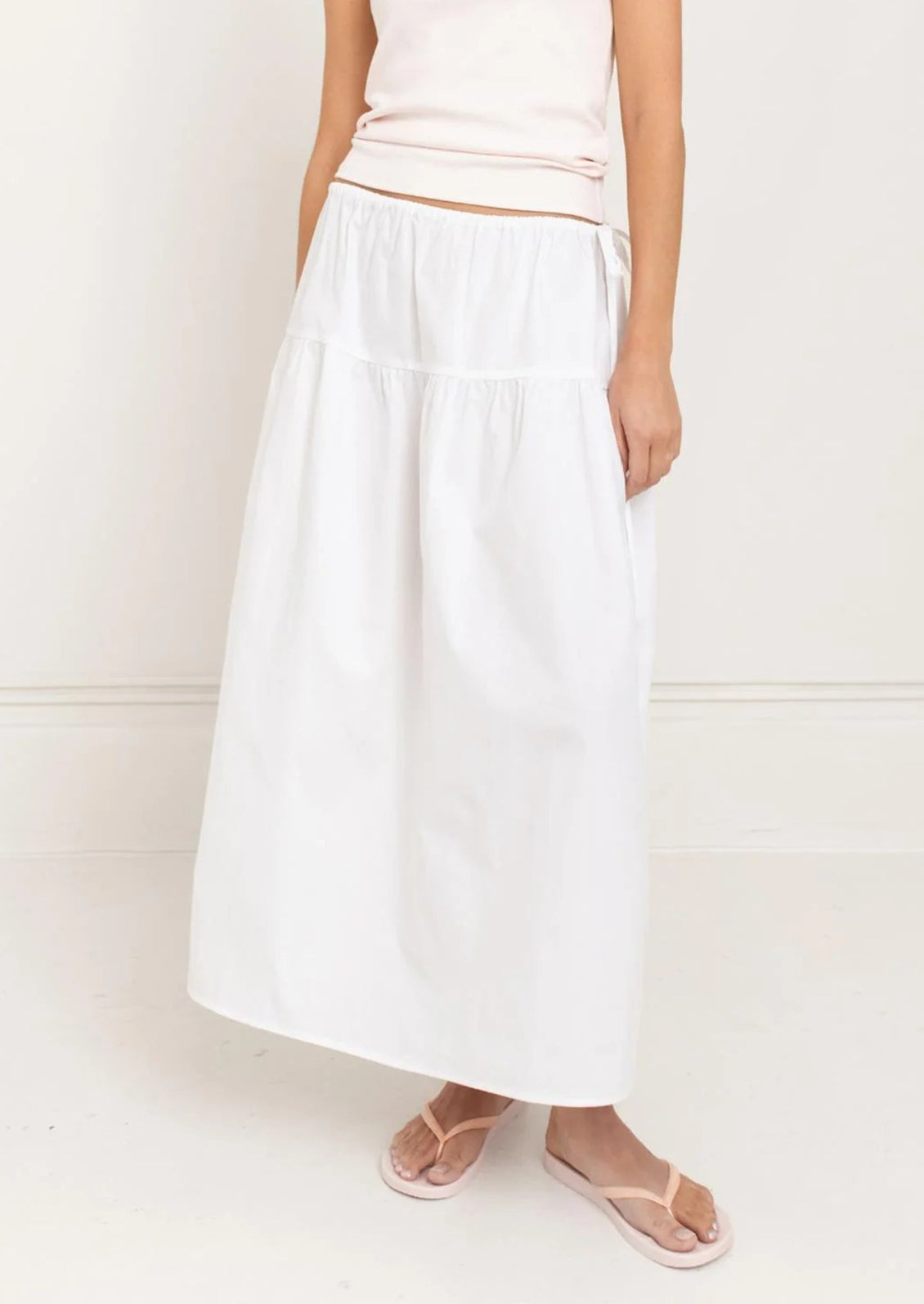 A person wearing a white midi skirt.