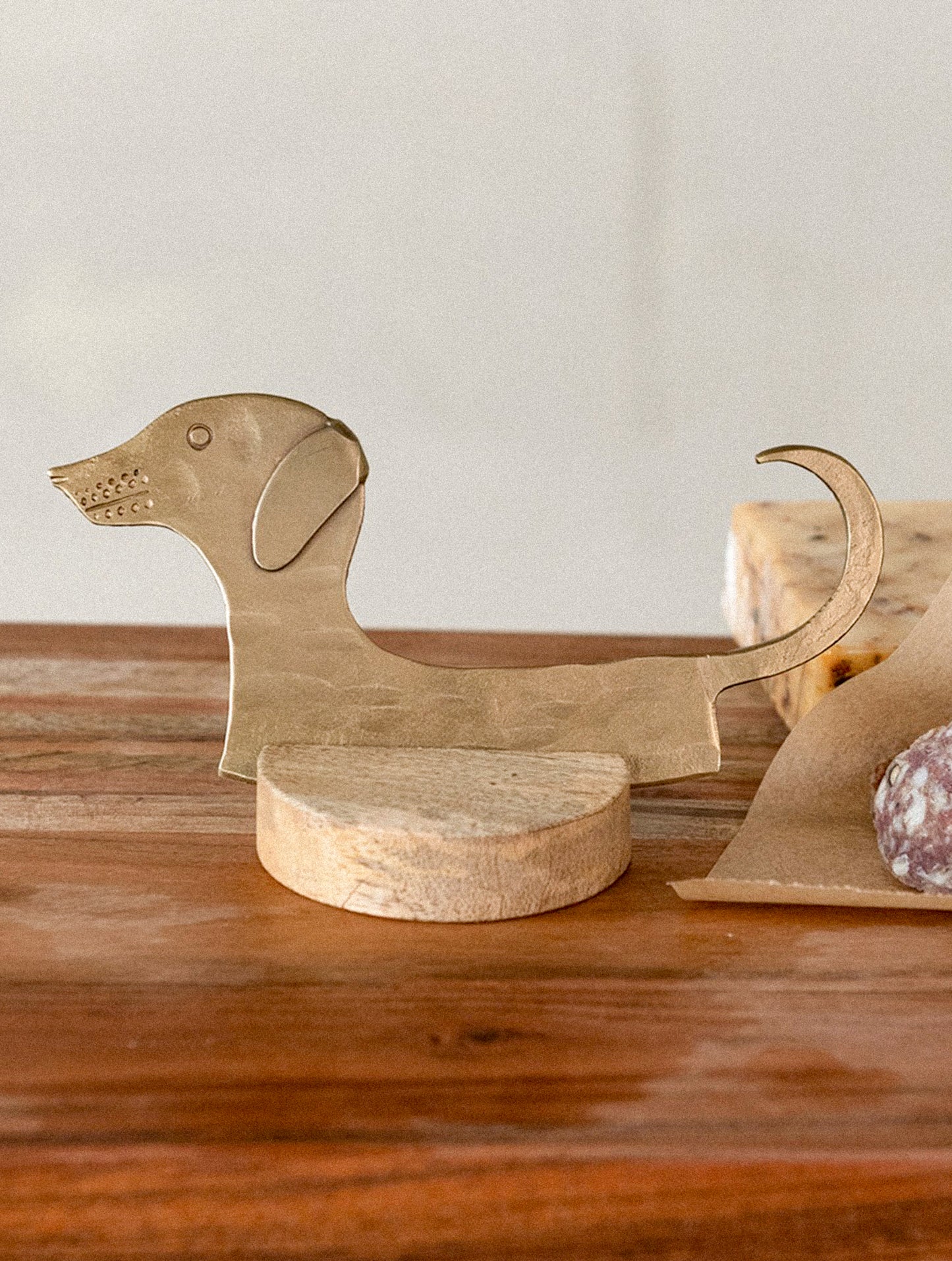 Brass dog-shaped cheese blade on a white background