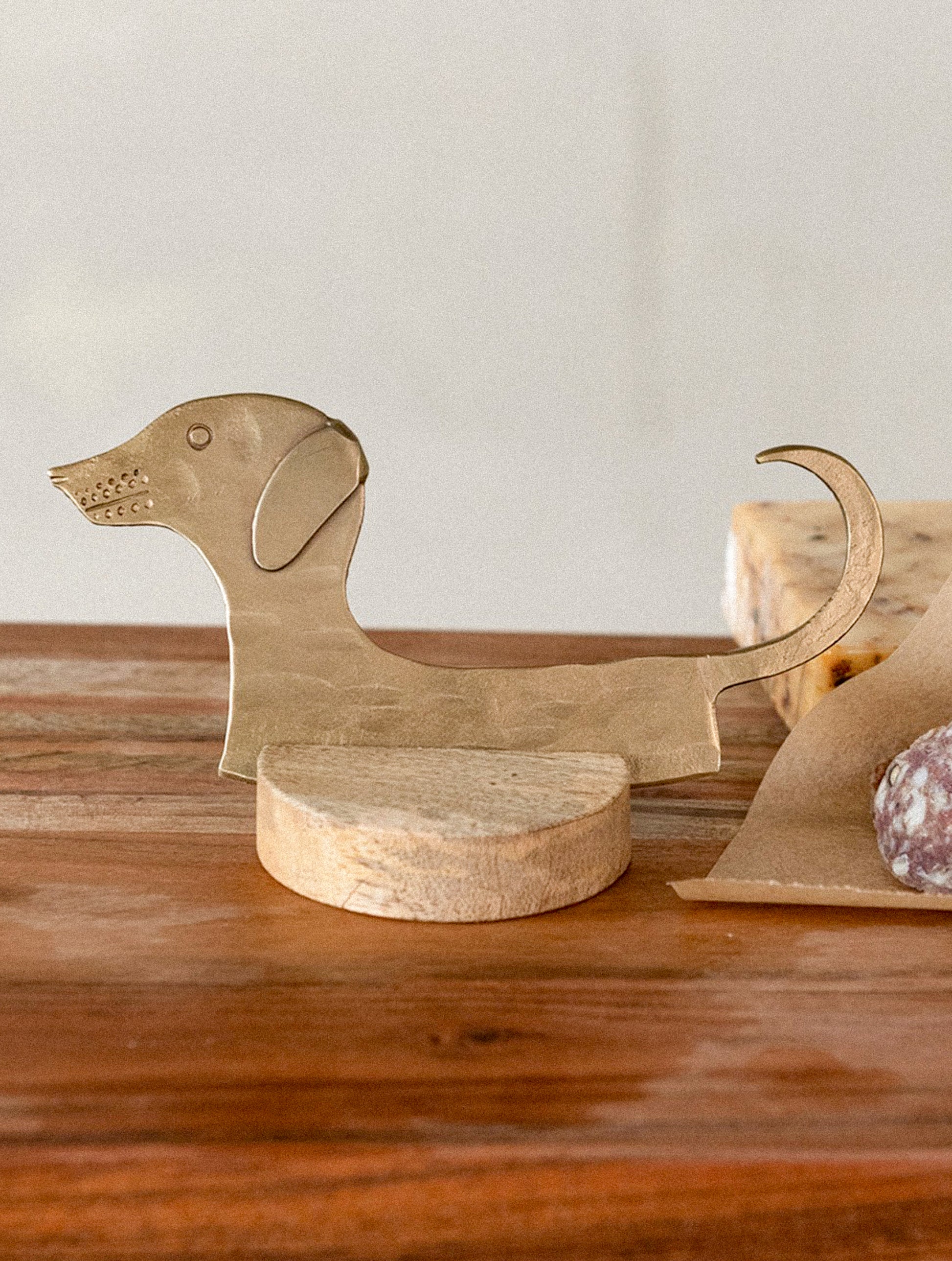 Brass dog-shaped cheese blade on a white background