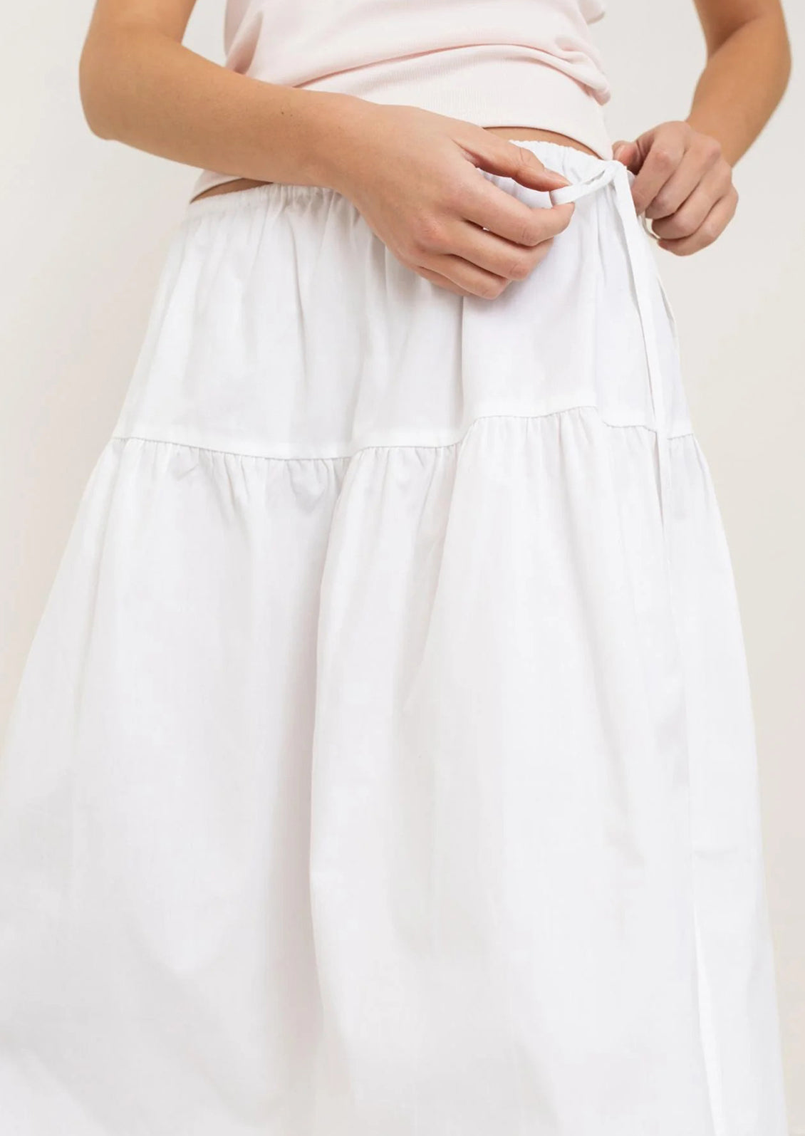 A person wearing a white midi skirt.