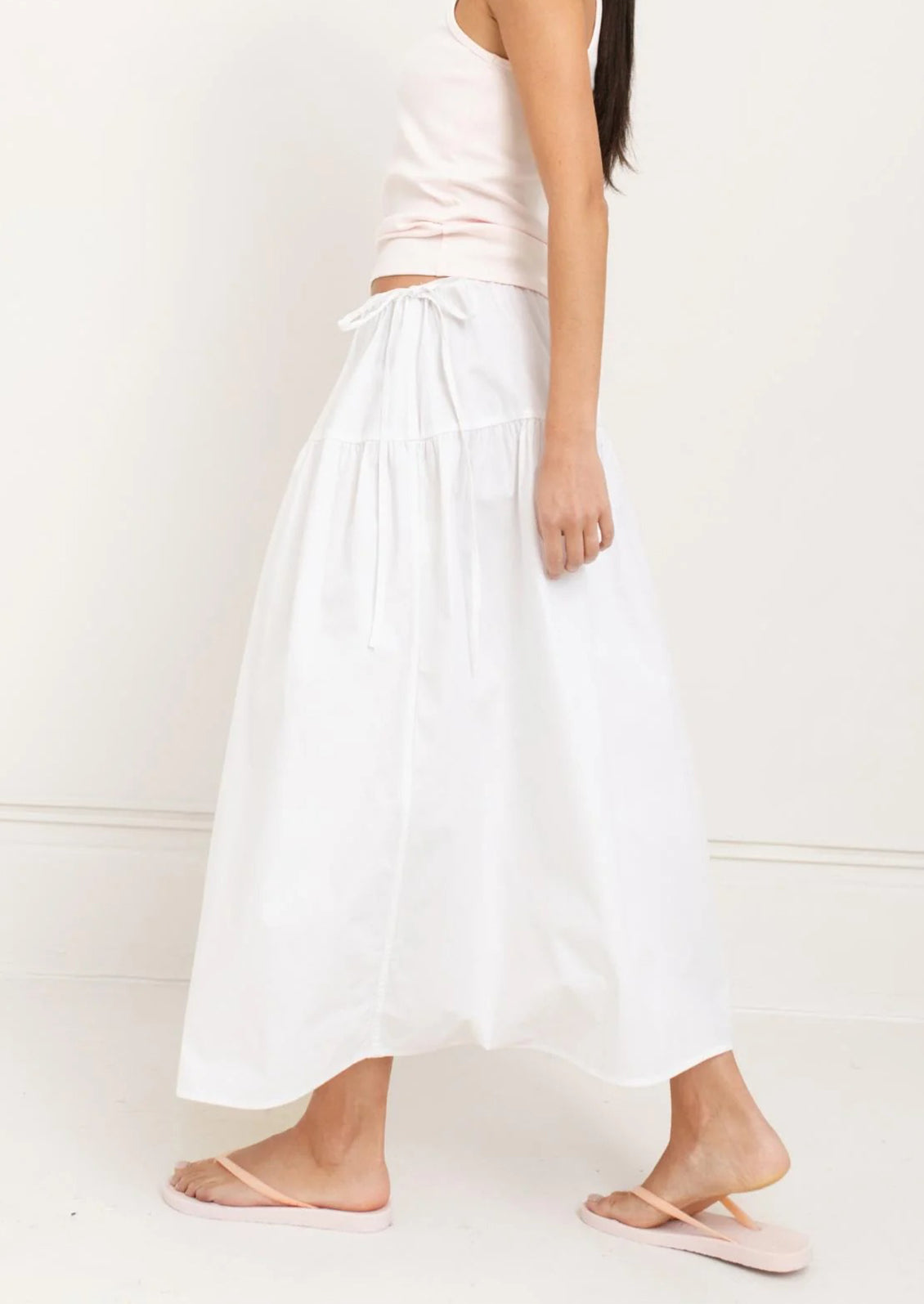 A person wearing a white midi skirt.