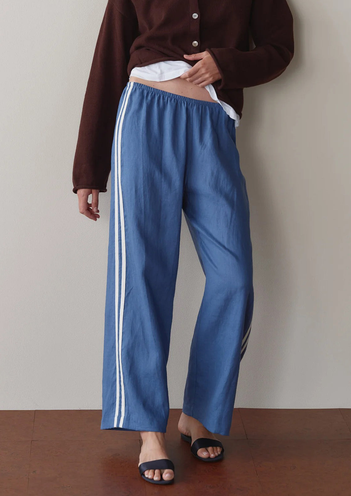 Person wearing blue pants with white stripes against a plain background