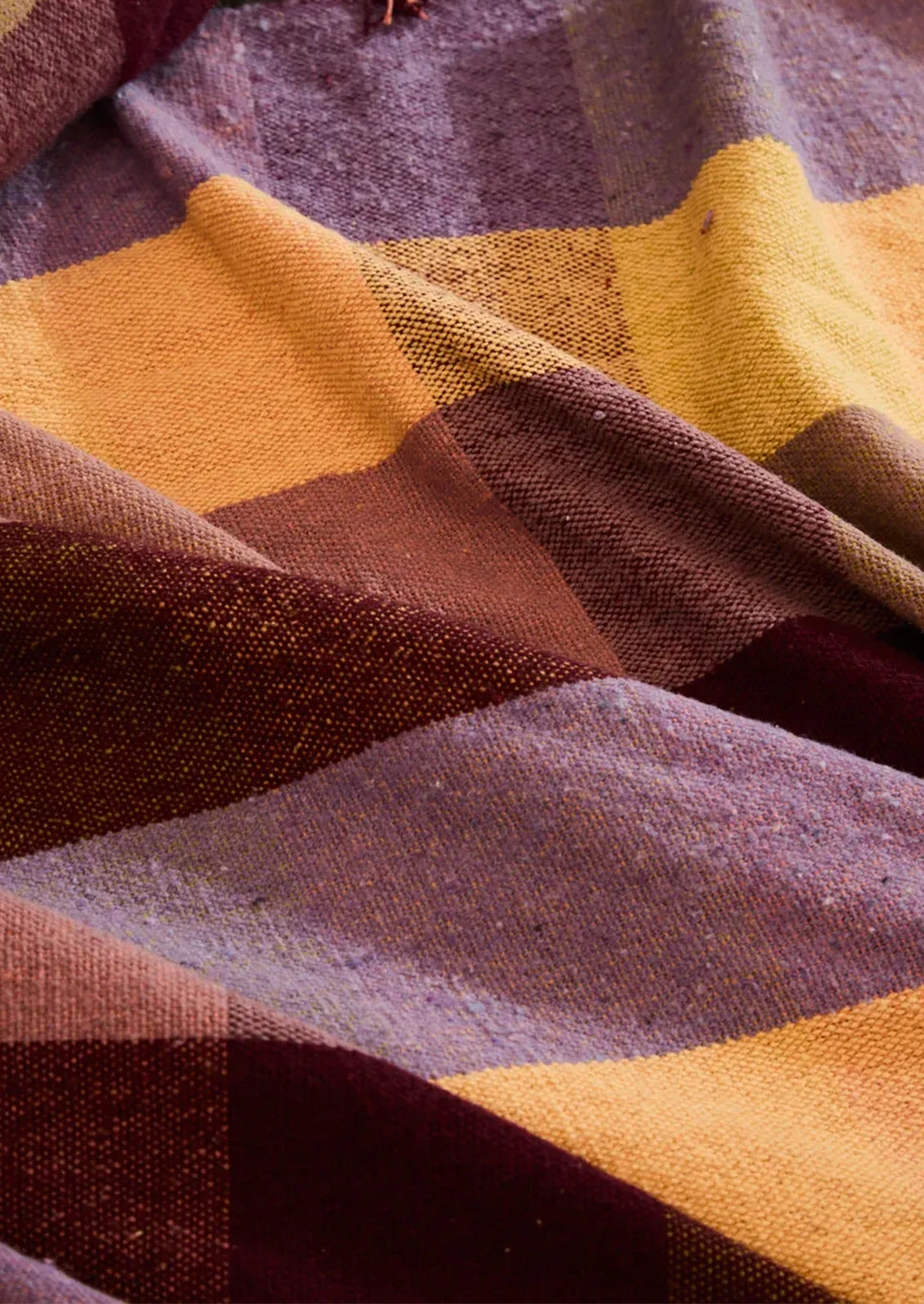 Close-up of a fabric with purple, yellow, and brown plaid pattern