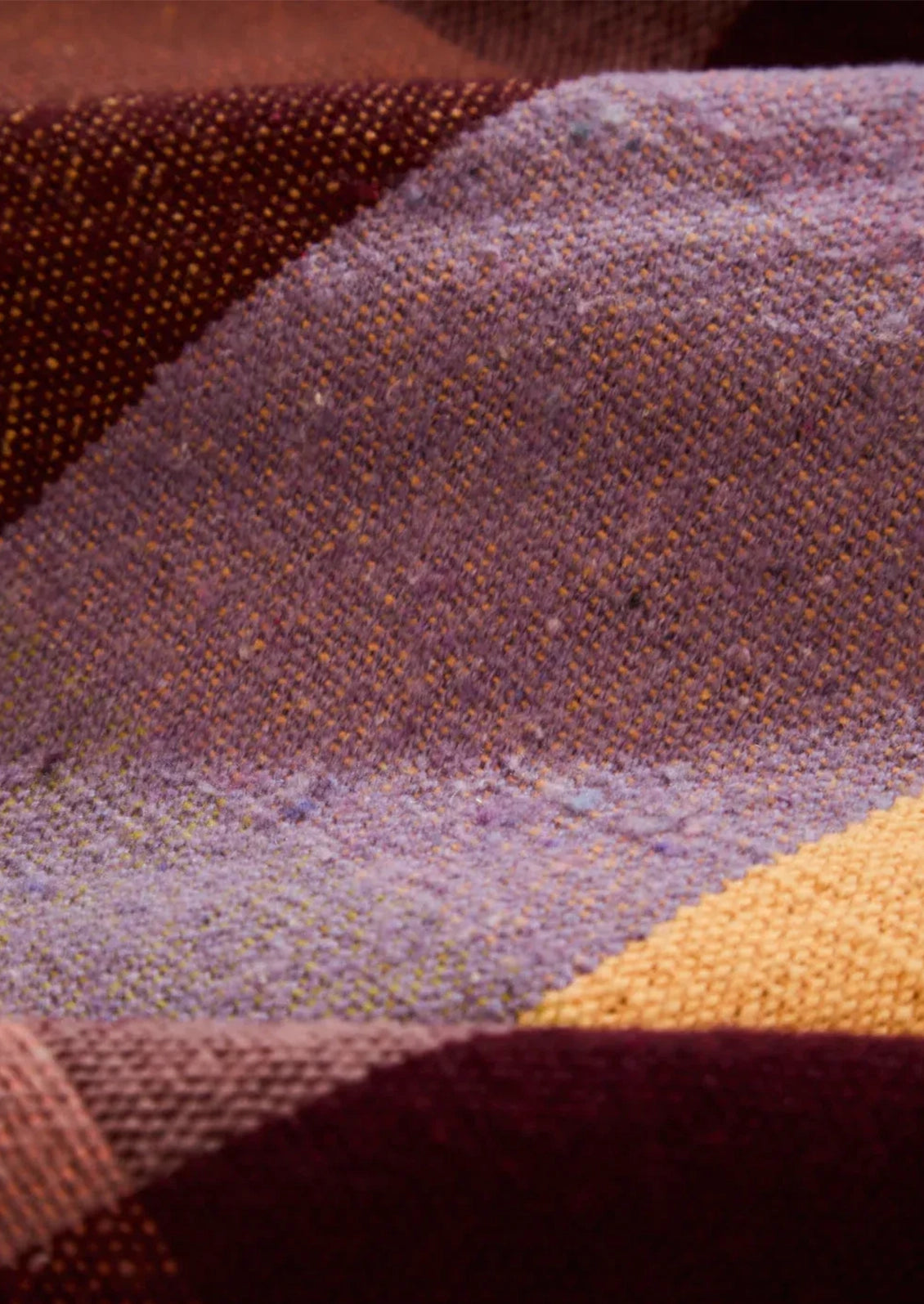 Close-up of a textured fabric with purple, brown, and gold colors.