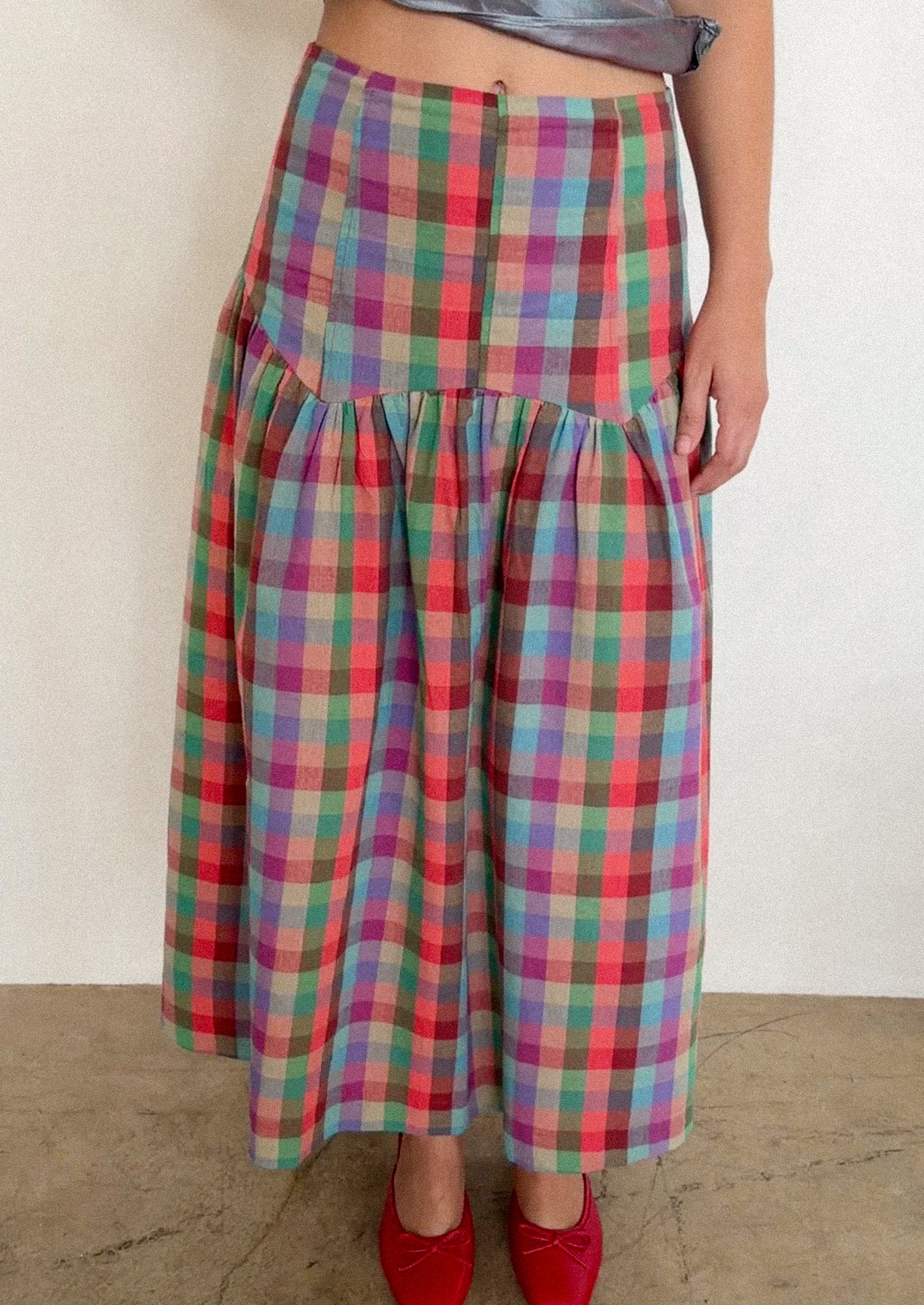 Multicolored plaid skirt worn by a person on a plain background