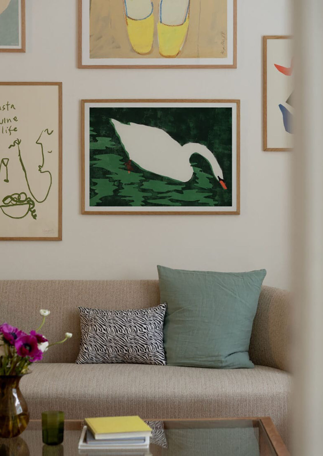 Living room with a beige sofa, decorative pillows, and framed artwork on the wall.