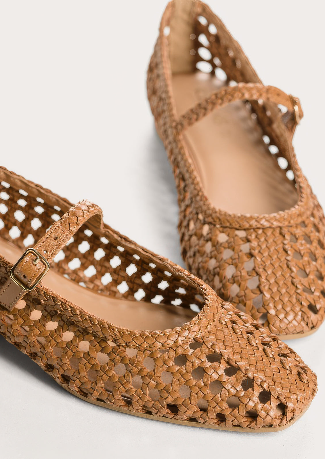 A pair of brown open weave ballet flats.