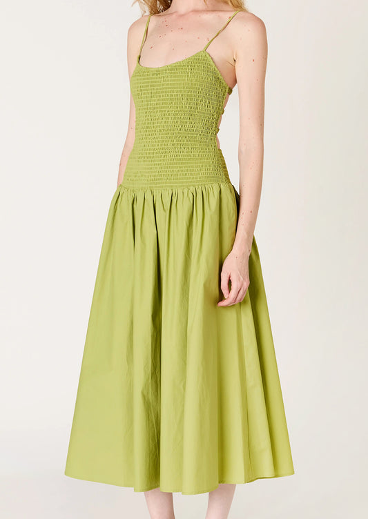 A person wearing a green dress with smocked bodice, full skirt and strappy open back.