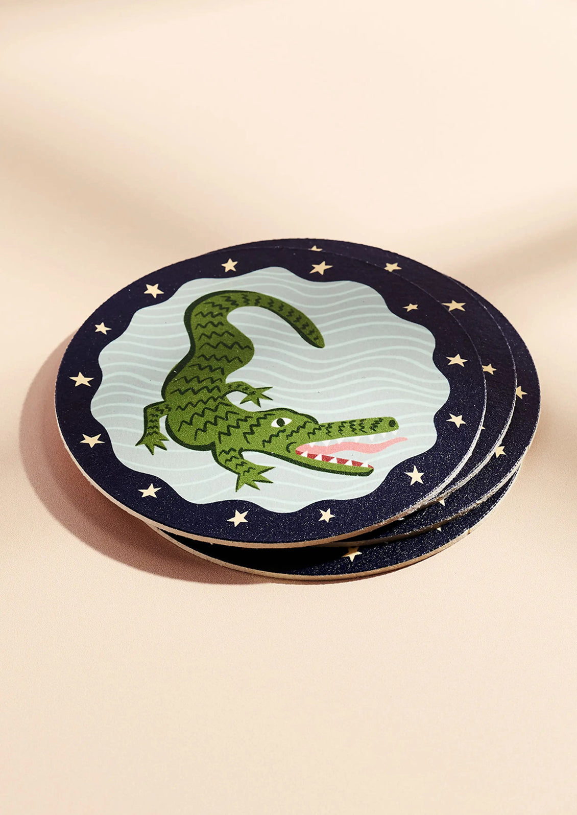 Set of coasters with a crocodile design on a beige background