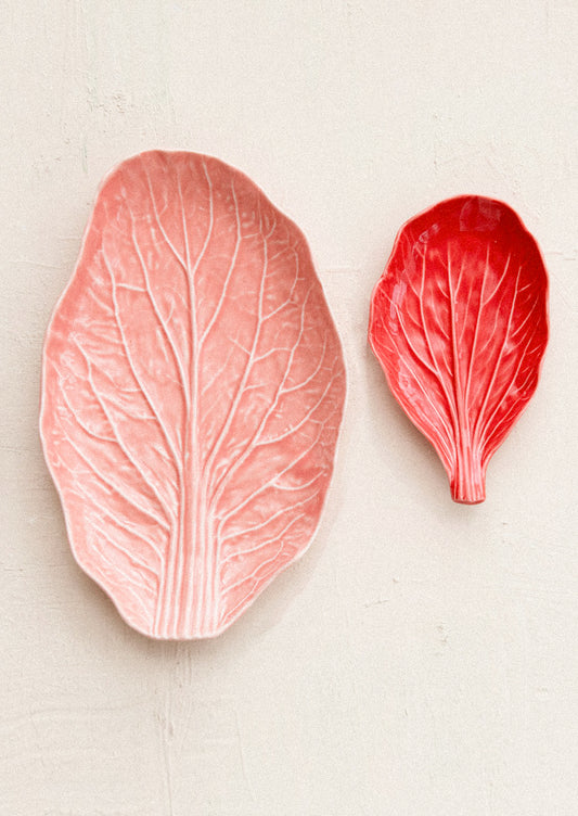 Two red leaf-shaped objects on a beige background