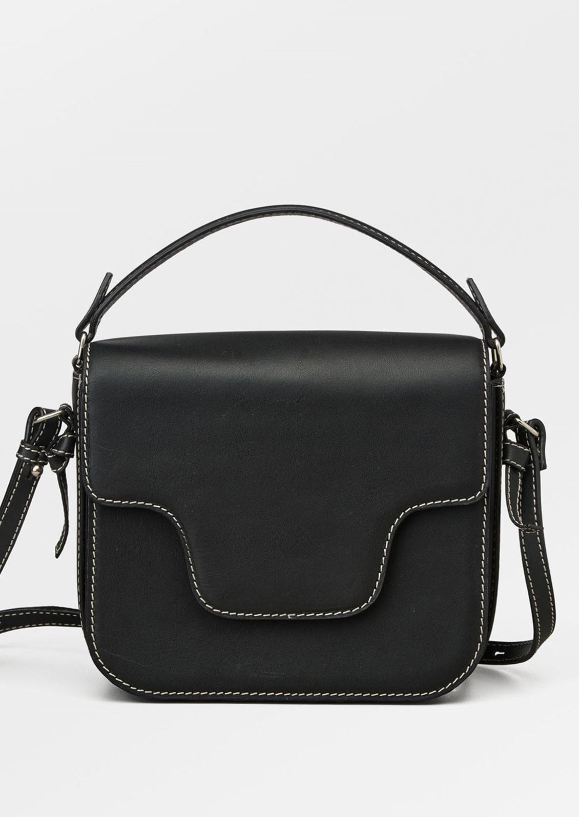 A leather handbag in black with white contrast stitching and flap front design.