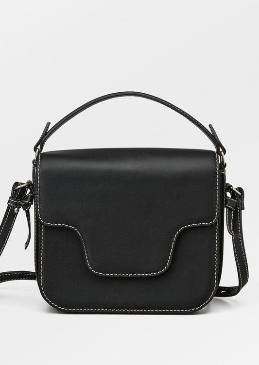 A leather handbag in black with white contrast stitching and flap front design.