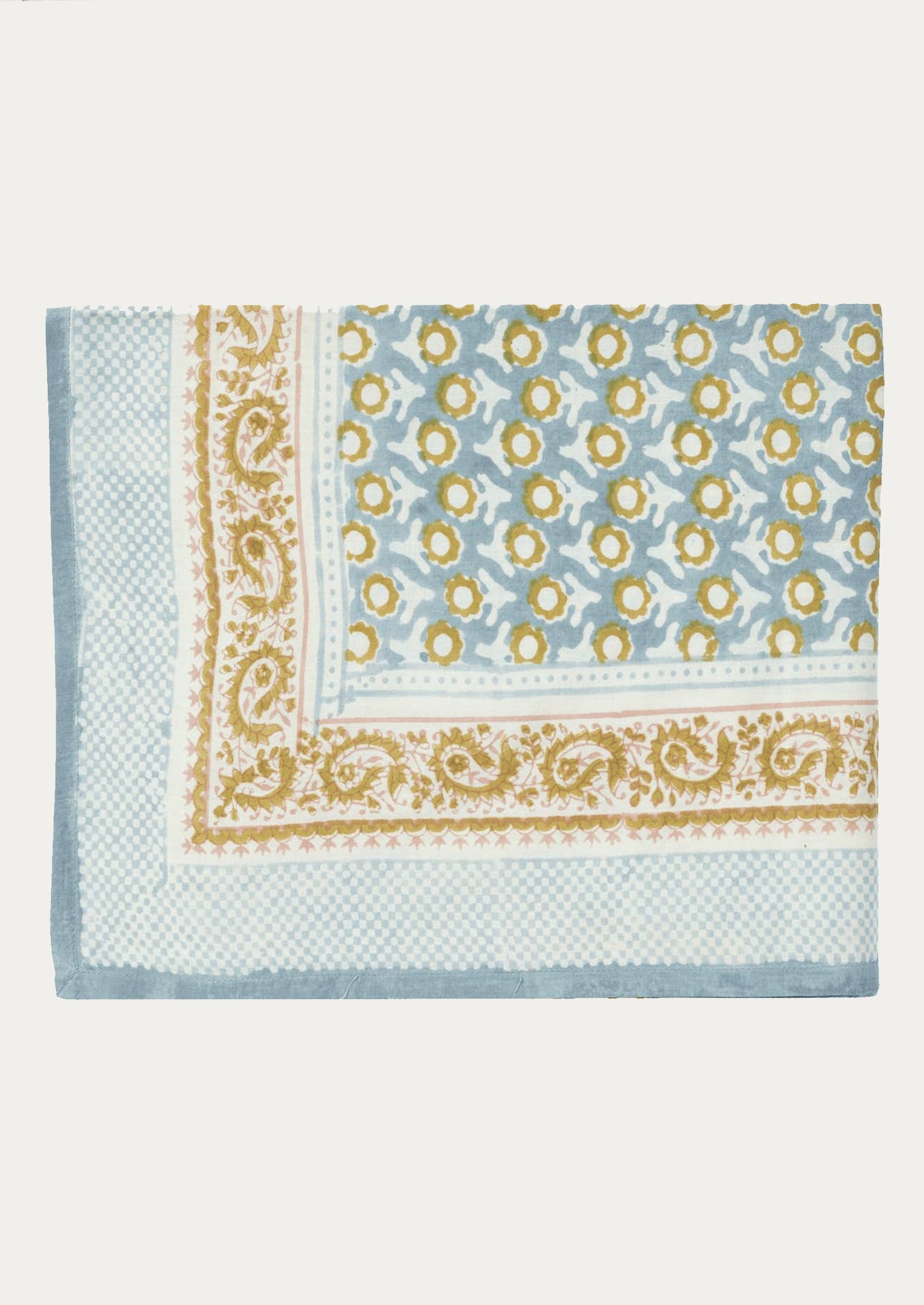 A block printed tablecloth in light blue and mustard paisley floral print.