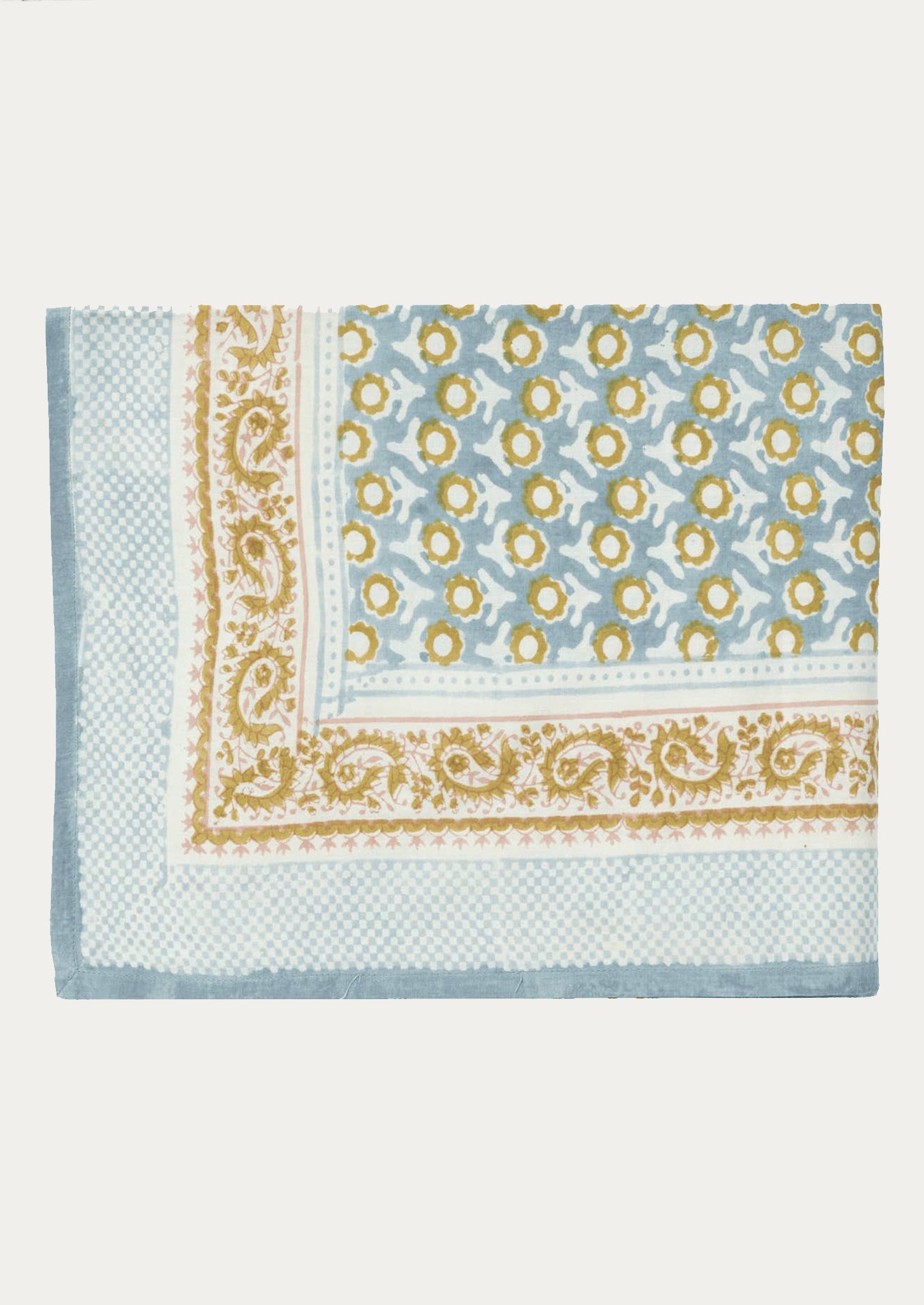 A block printed tablecloth in light blue and mustard paisley floral print.