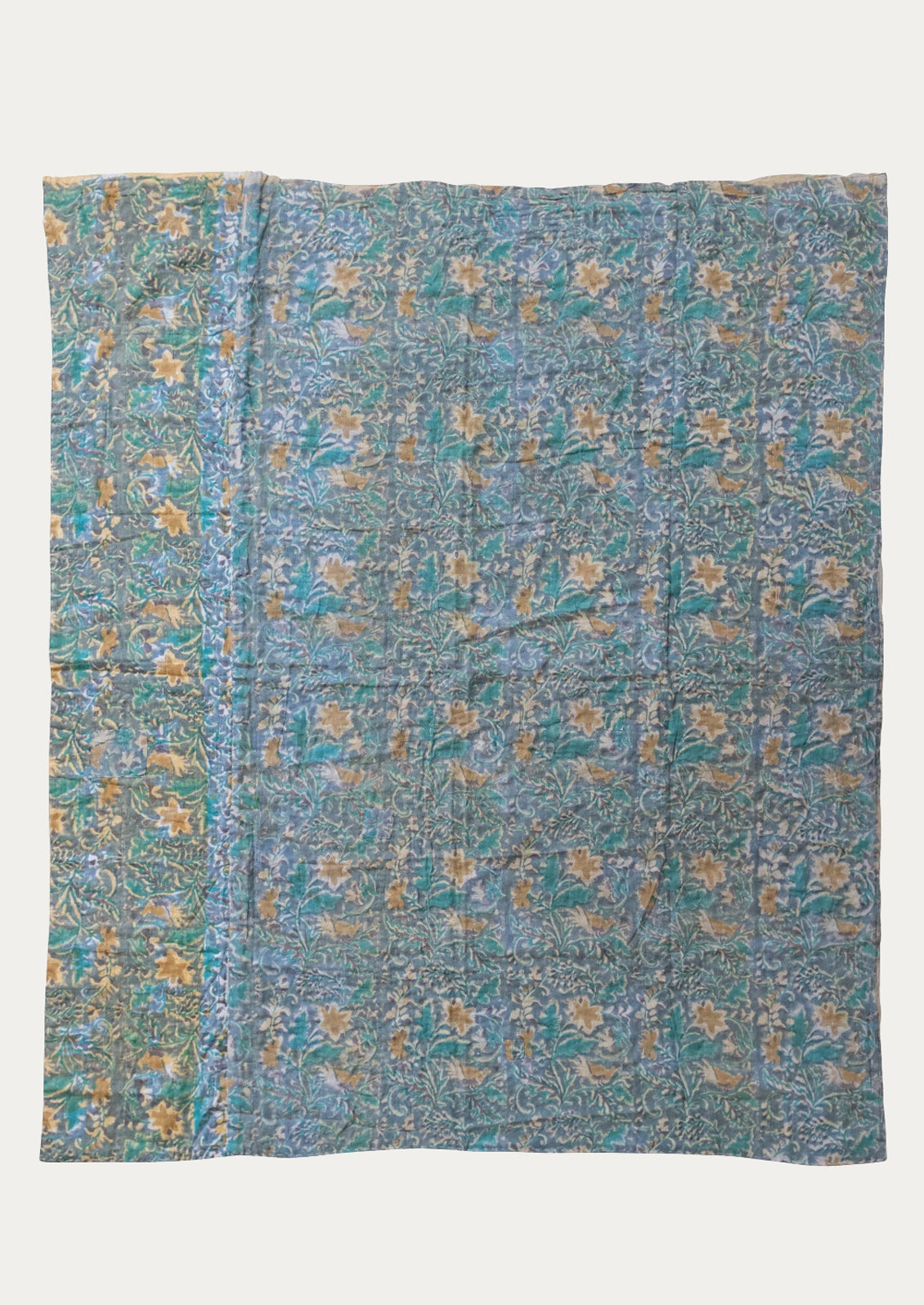 A vintage kantha throw with floral print in grey, yellow, blue and turquoise tones.