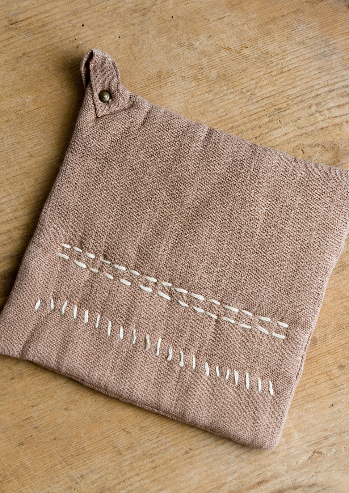 A cotton holder in clay with decorative contrast stitching in ivory.