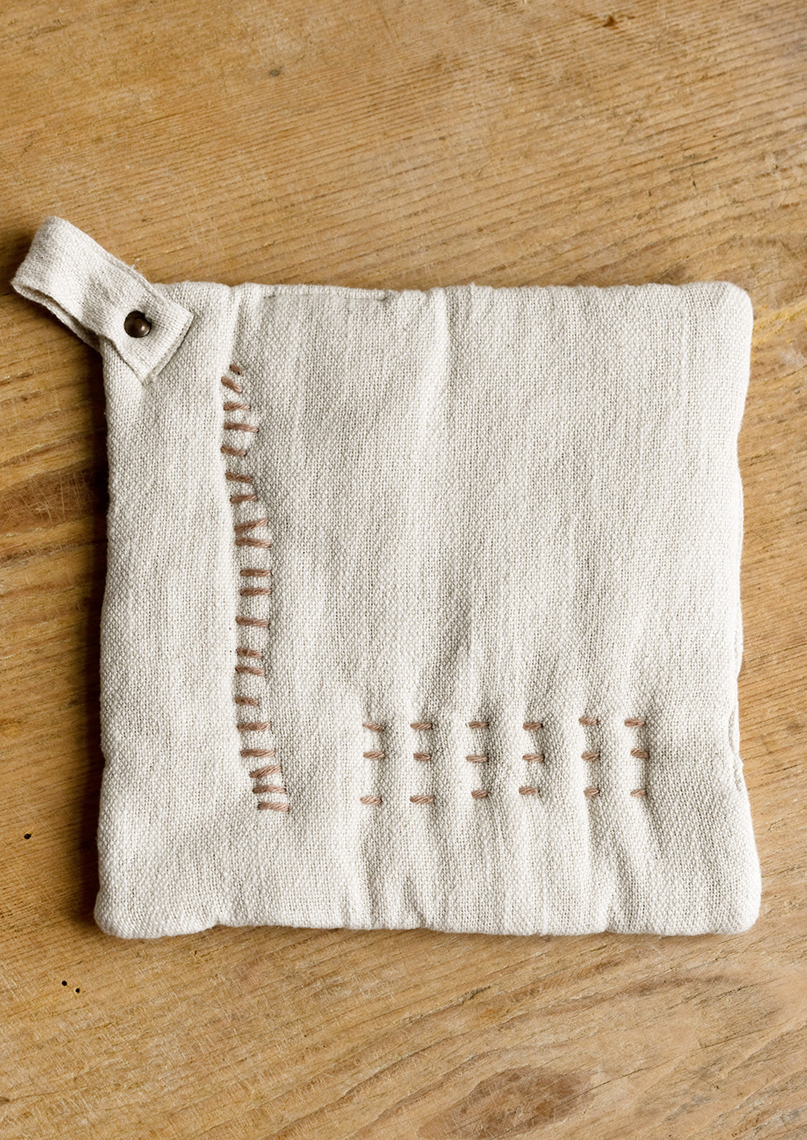 A cotton holder in ivory with decorative contrast stitching in clay.