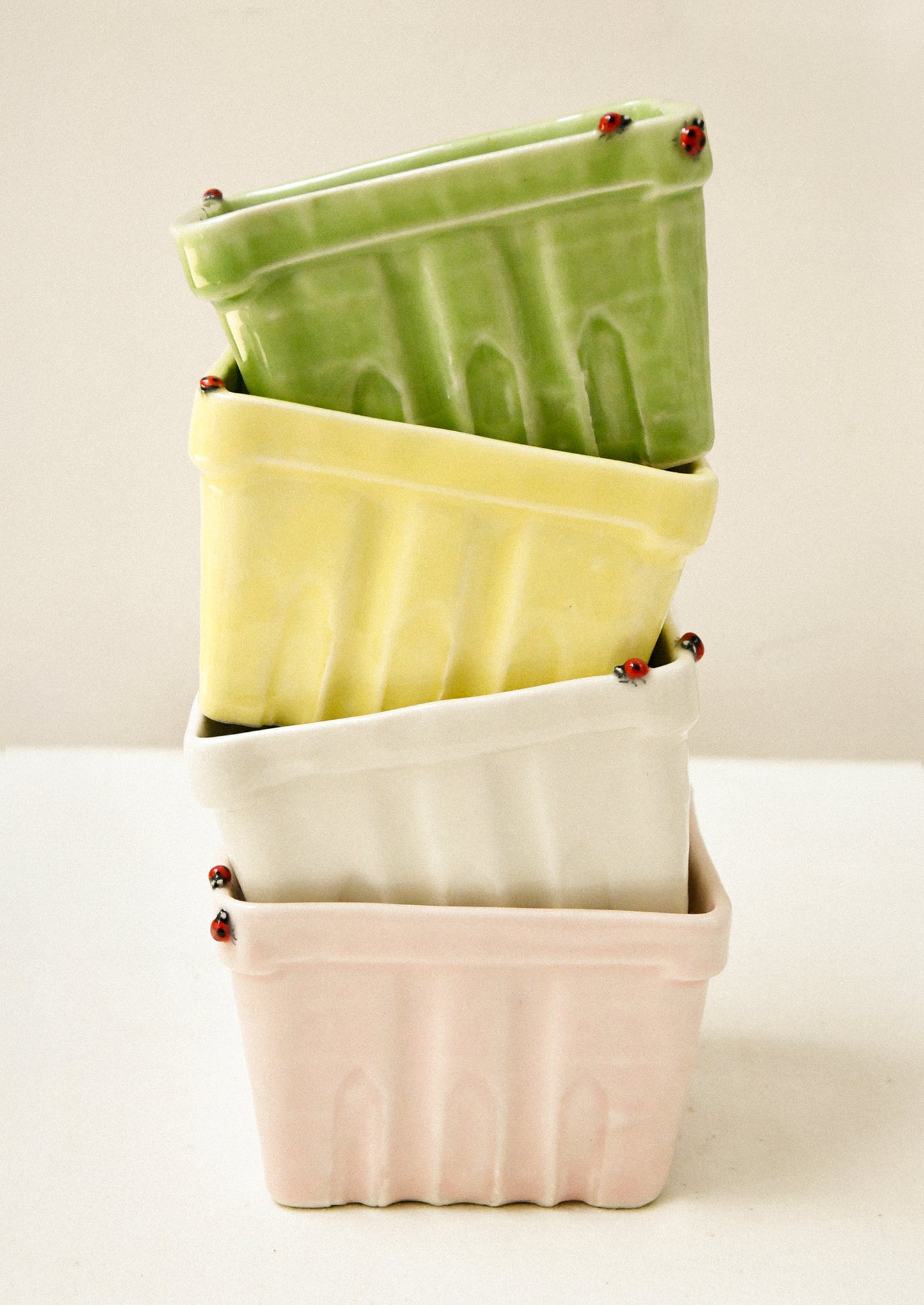 Colorful ceramic berry baskets adorned with little ladybugs.