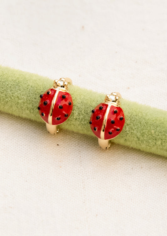 A pair of hoop earrings with ladybugs on them.