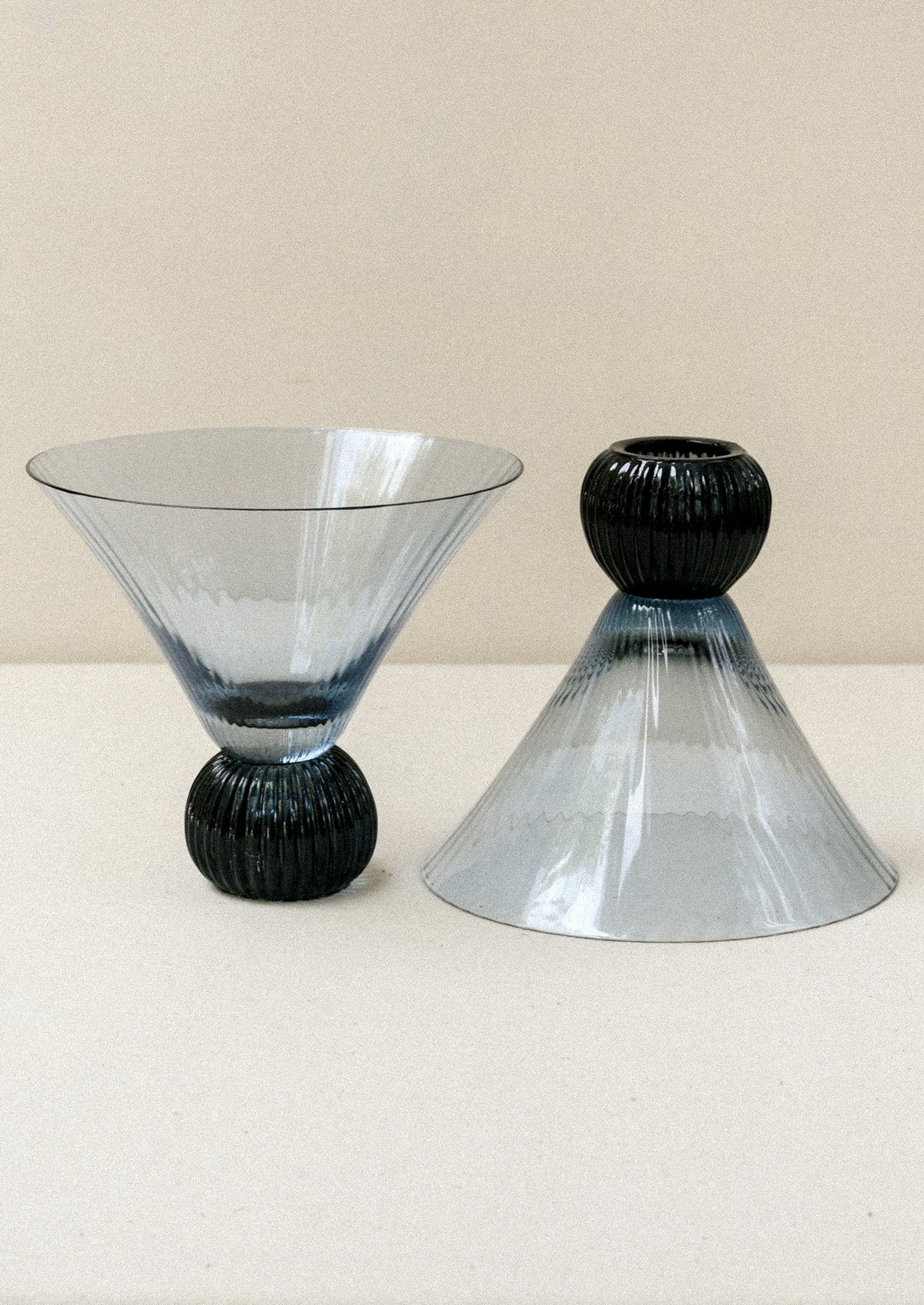 Two short blue glass martini glasses with ribbed, flared shape.