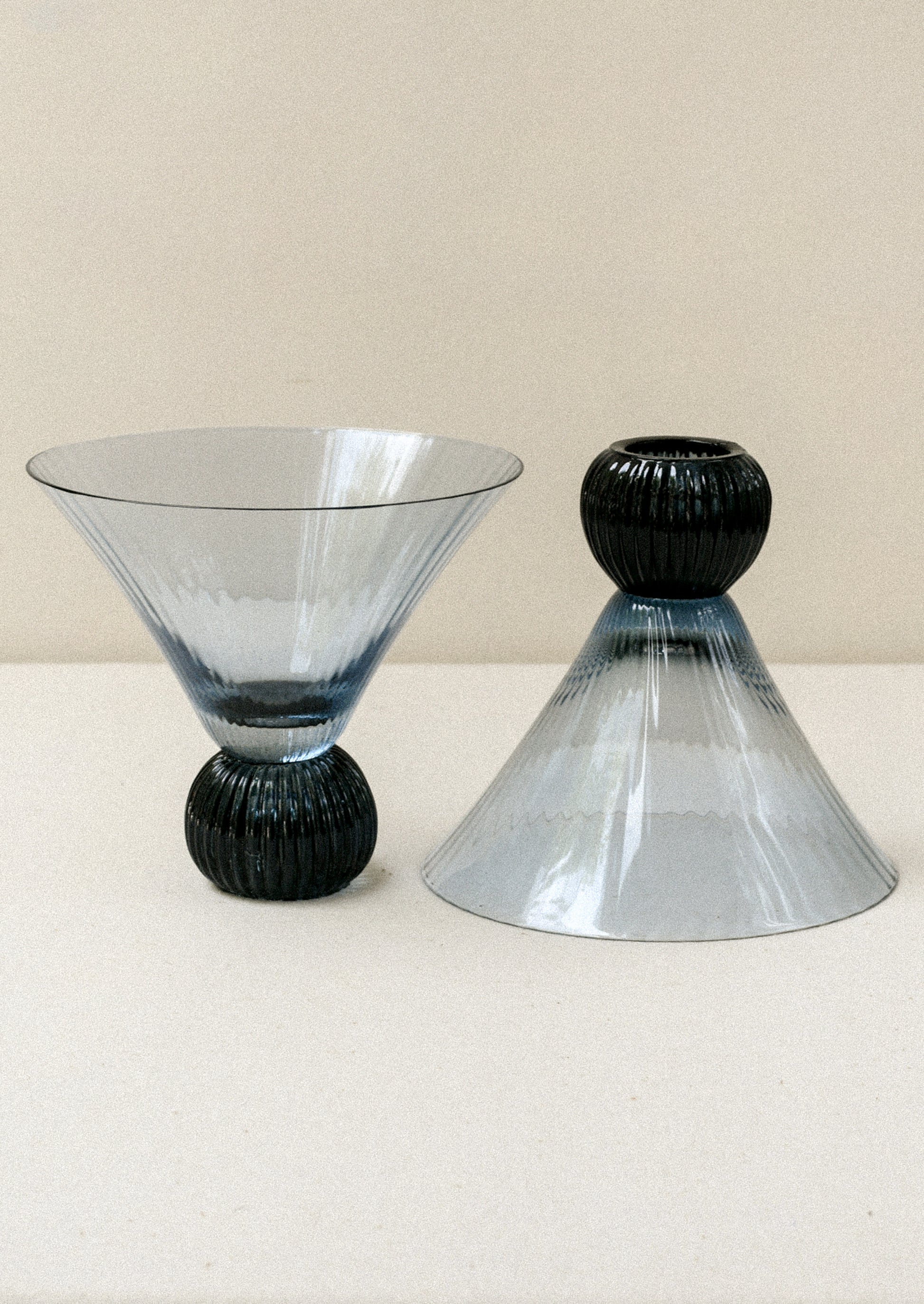 Two short blue glass martini glasses with ribbed, flared shape.