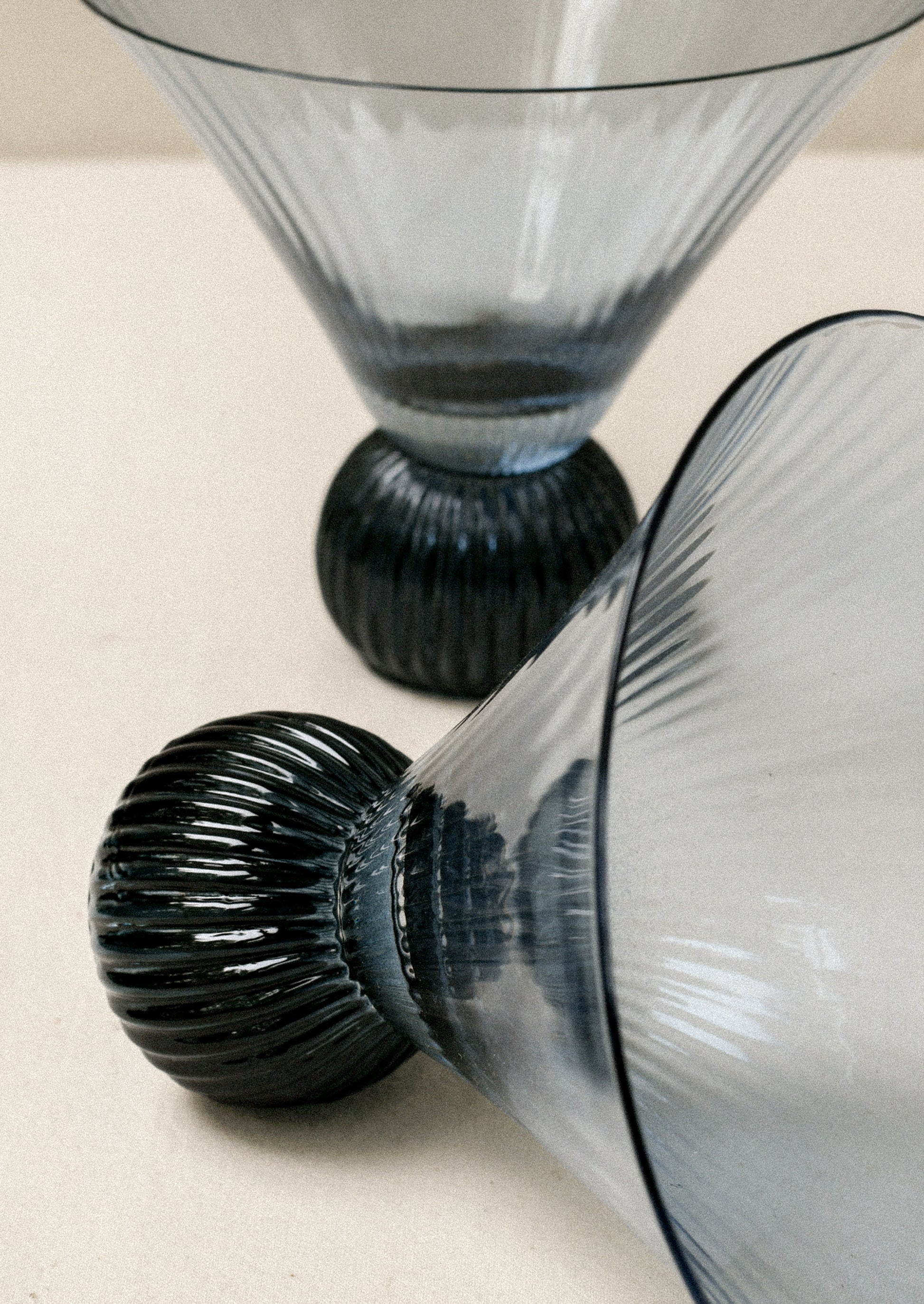 Two short blue glass martini glasses with ribbed, flared shape.