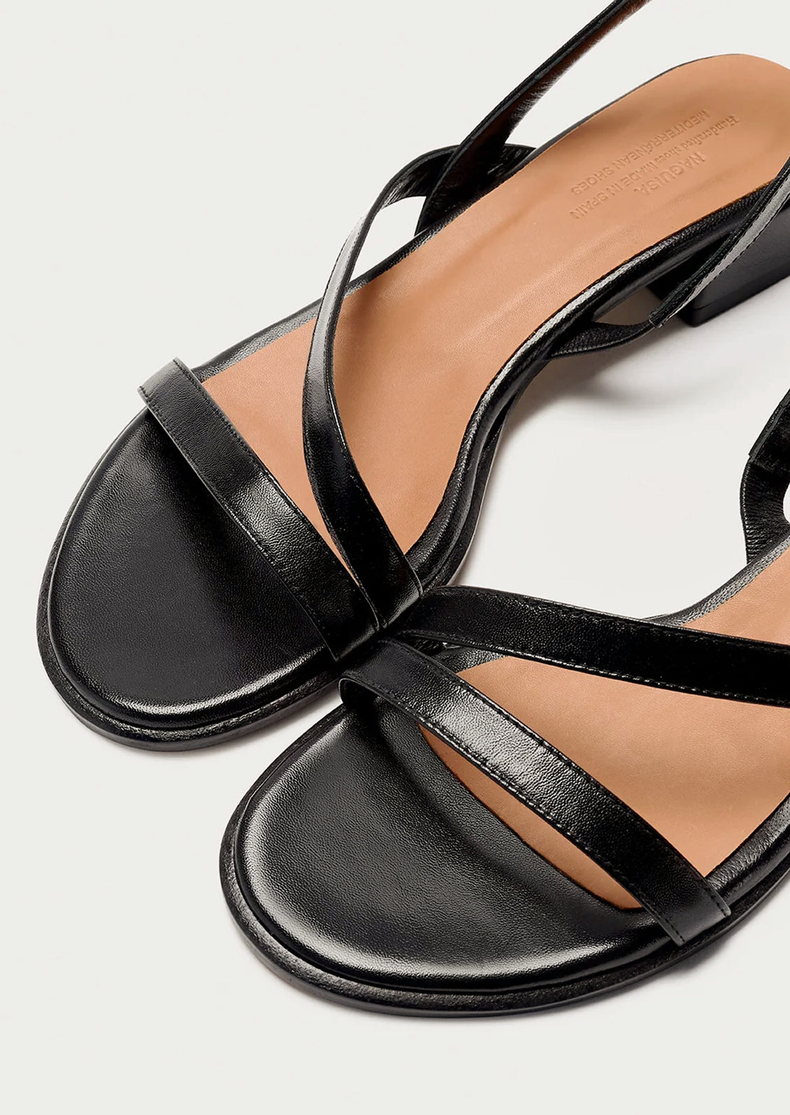 A pair of strappy black leather sandals with a chunky heel.
