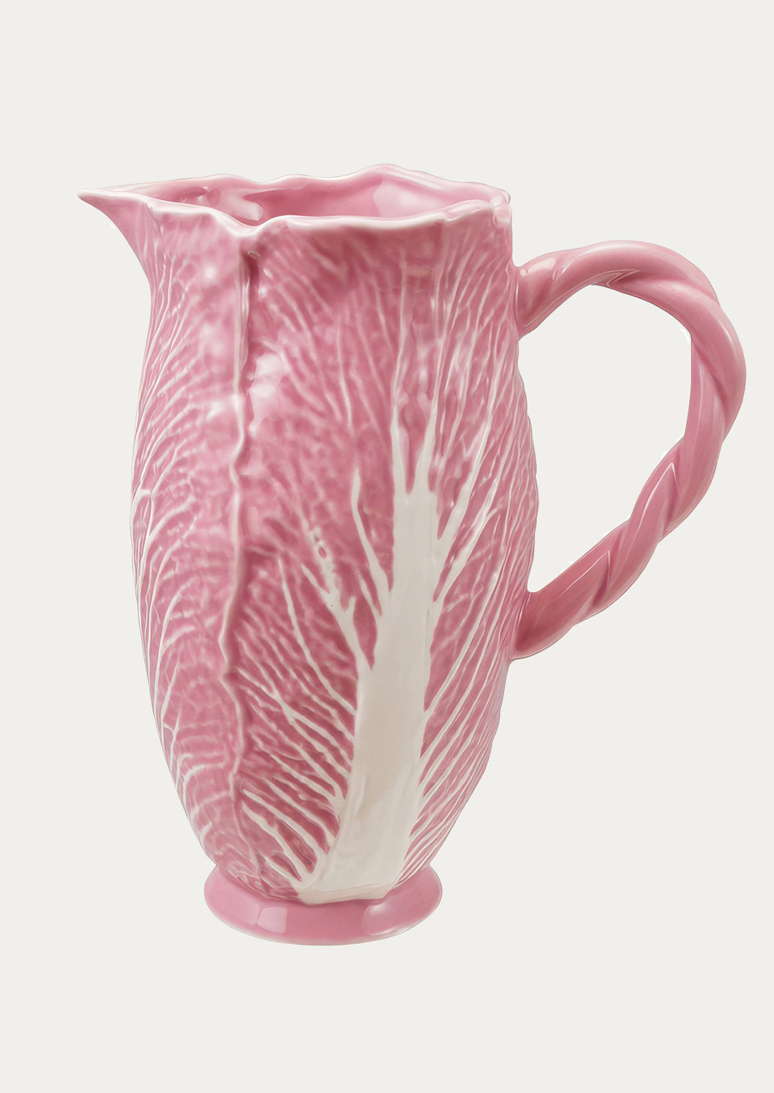 Pink ceramic pitcher with leaf pattern on a white background