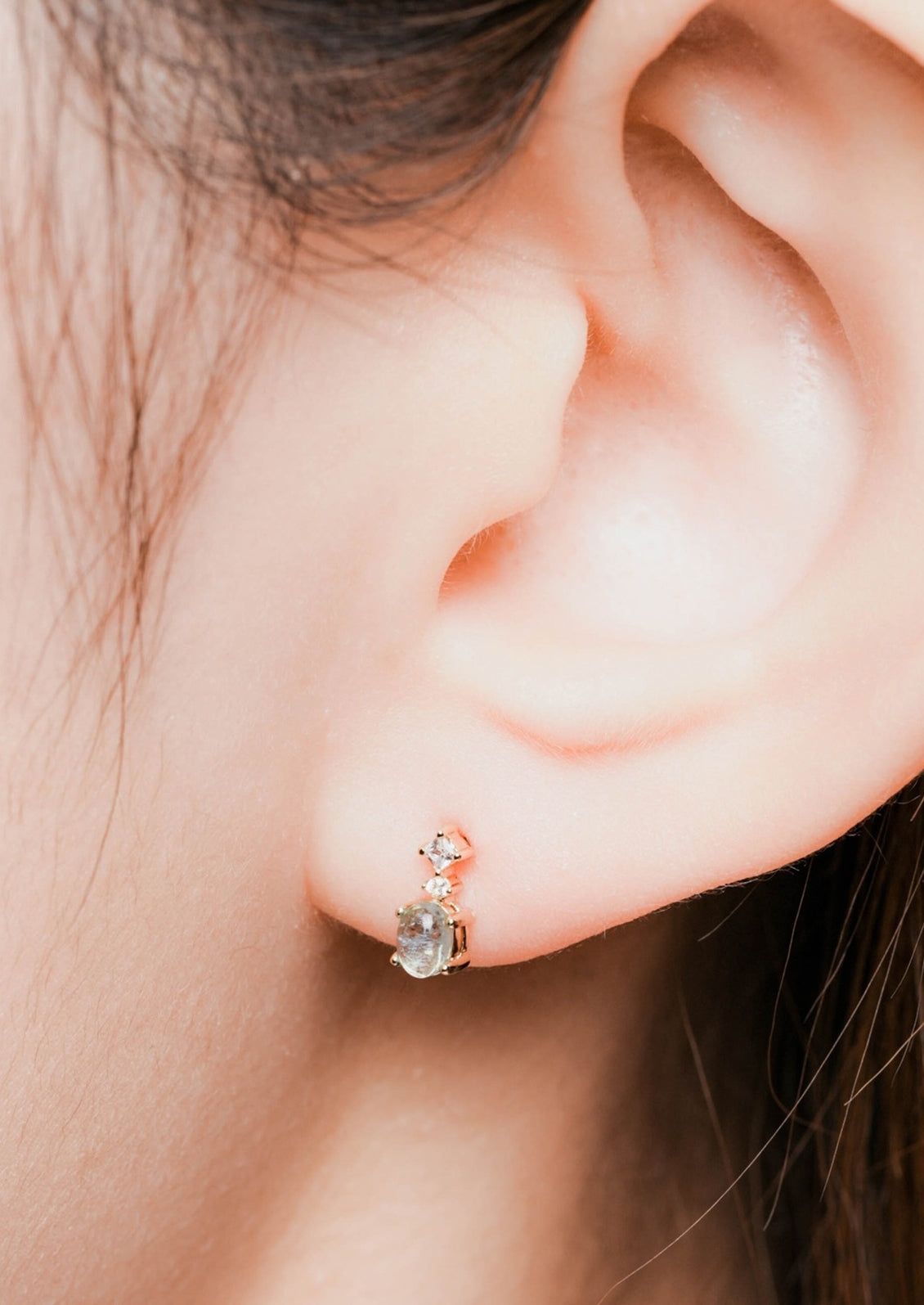 A pair of small aquamarine stud earrings in gold with crystal detail.