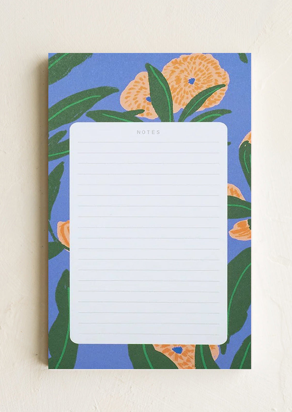 A ruled notepad with patterned background border in blue floral print.