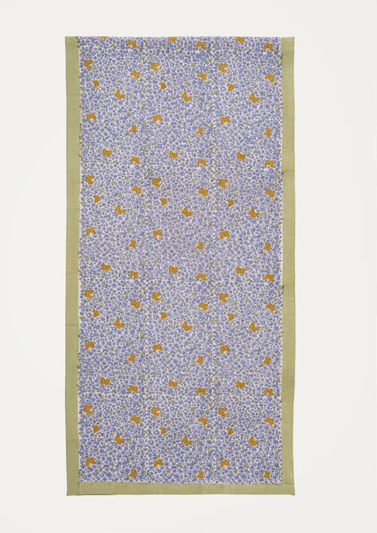 A table runner with lavender floral print and orange butterflies with sage green border.